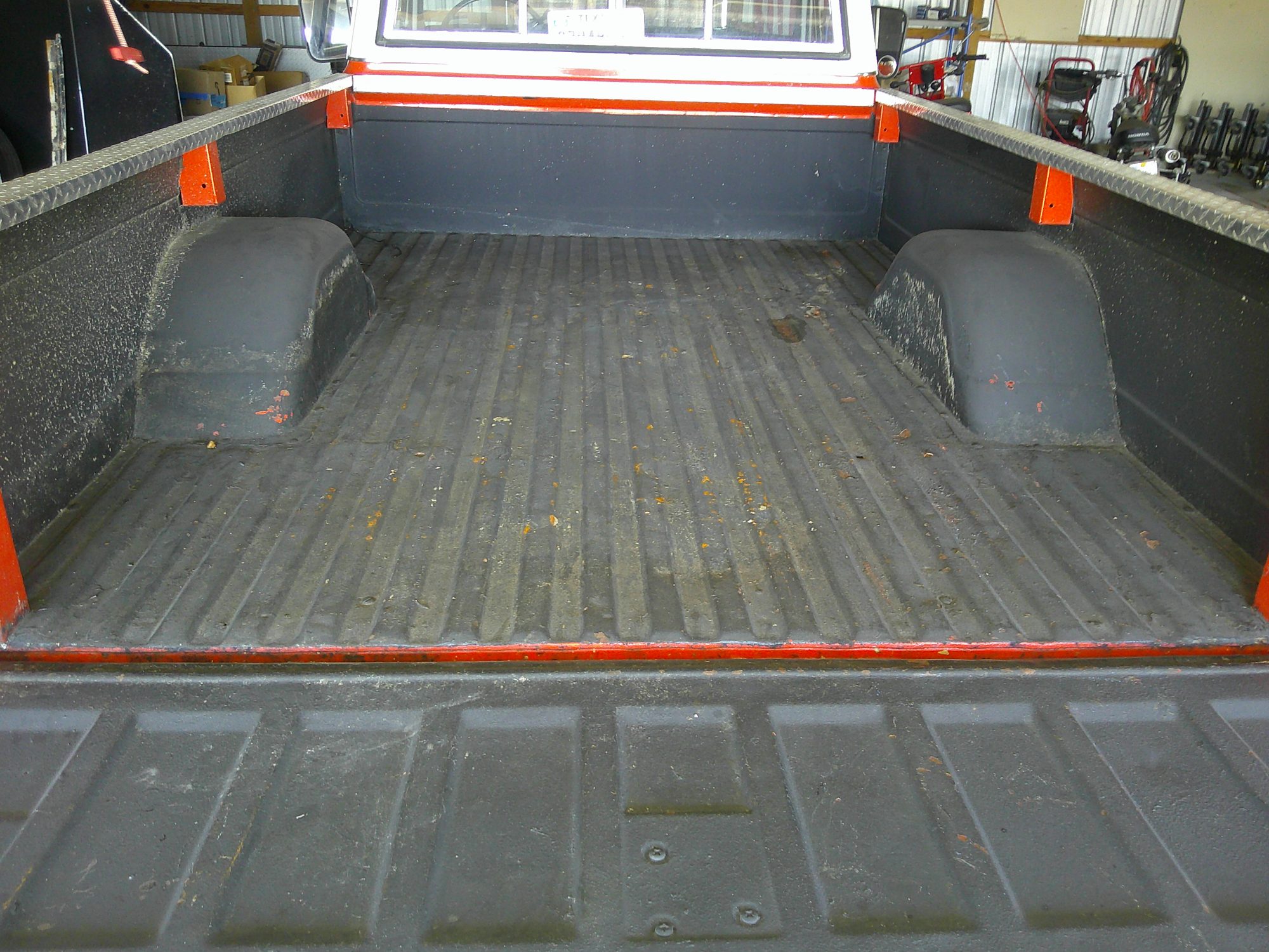 View of the pickup truck bed with black liner and tailgate open.