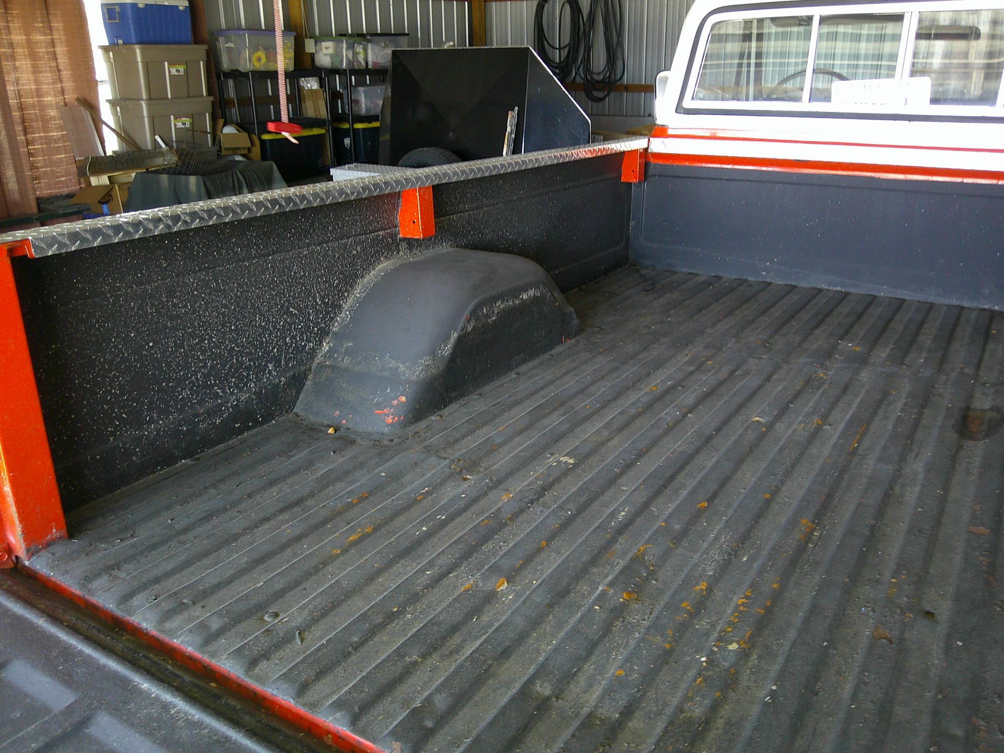 View of the pickup truck bed with textured liner and diamond plate rail caps.