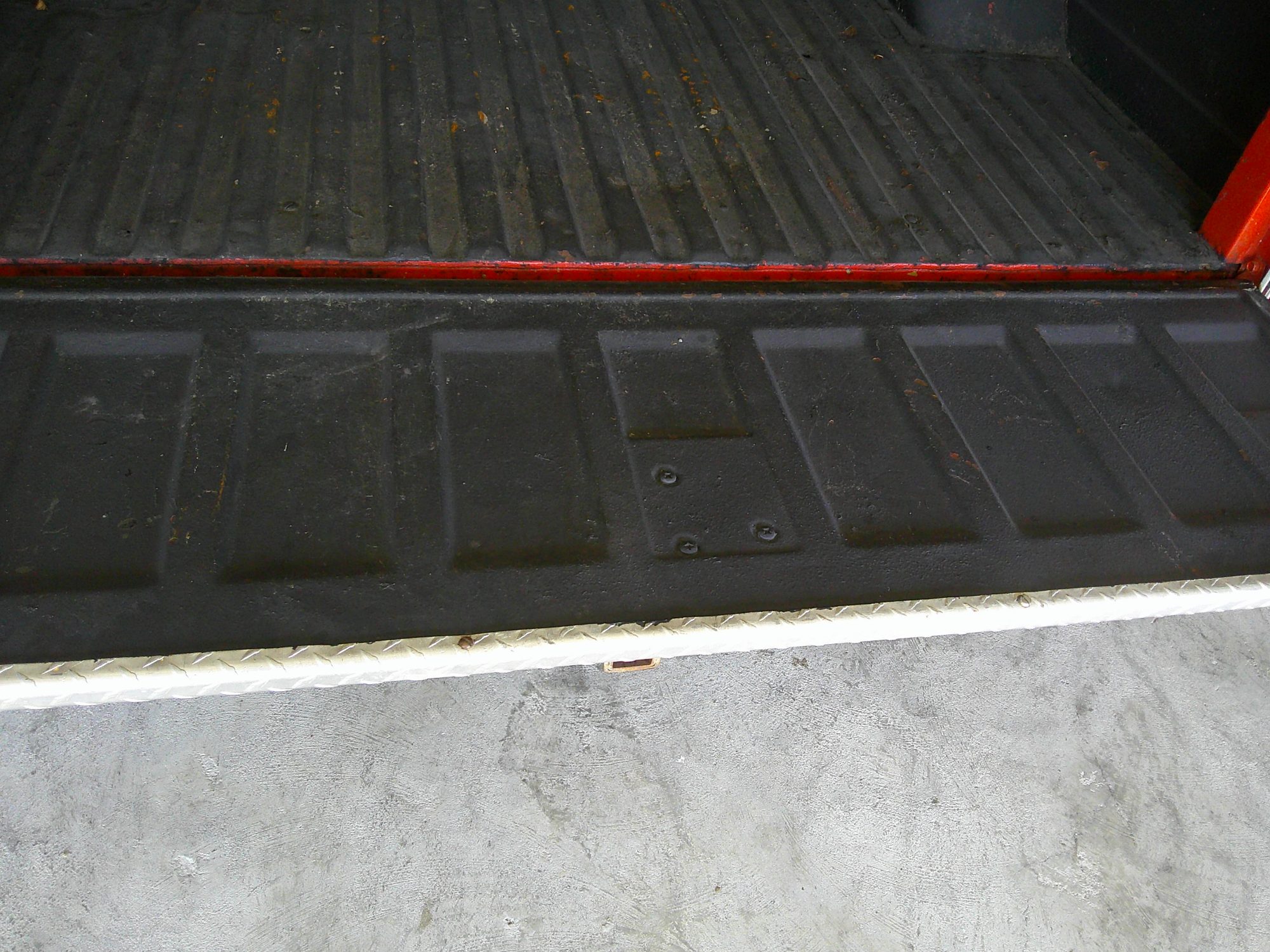 View of the pickup truck bed and lowered tailgate with black liner.