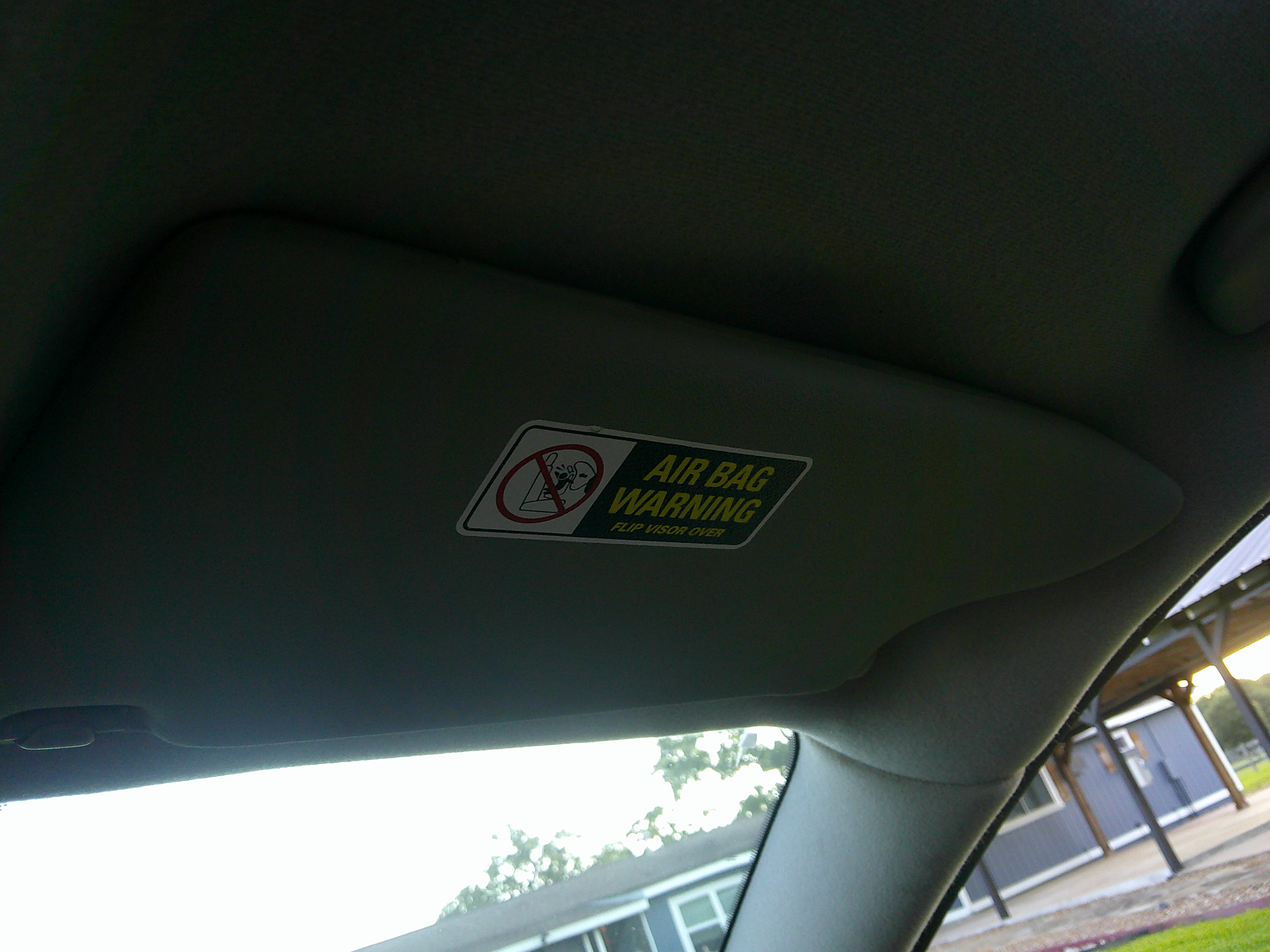 Passenger side sun visor with air bag warning label