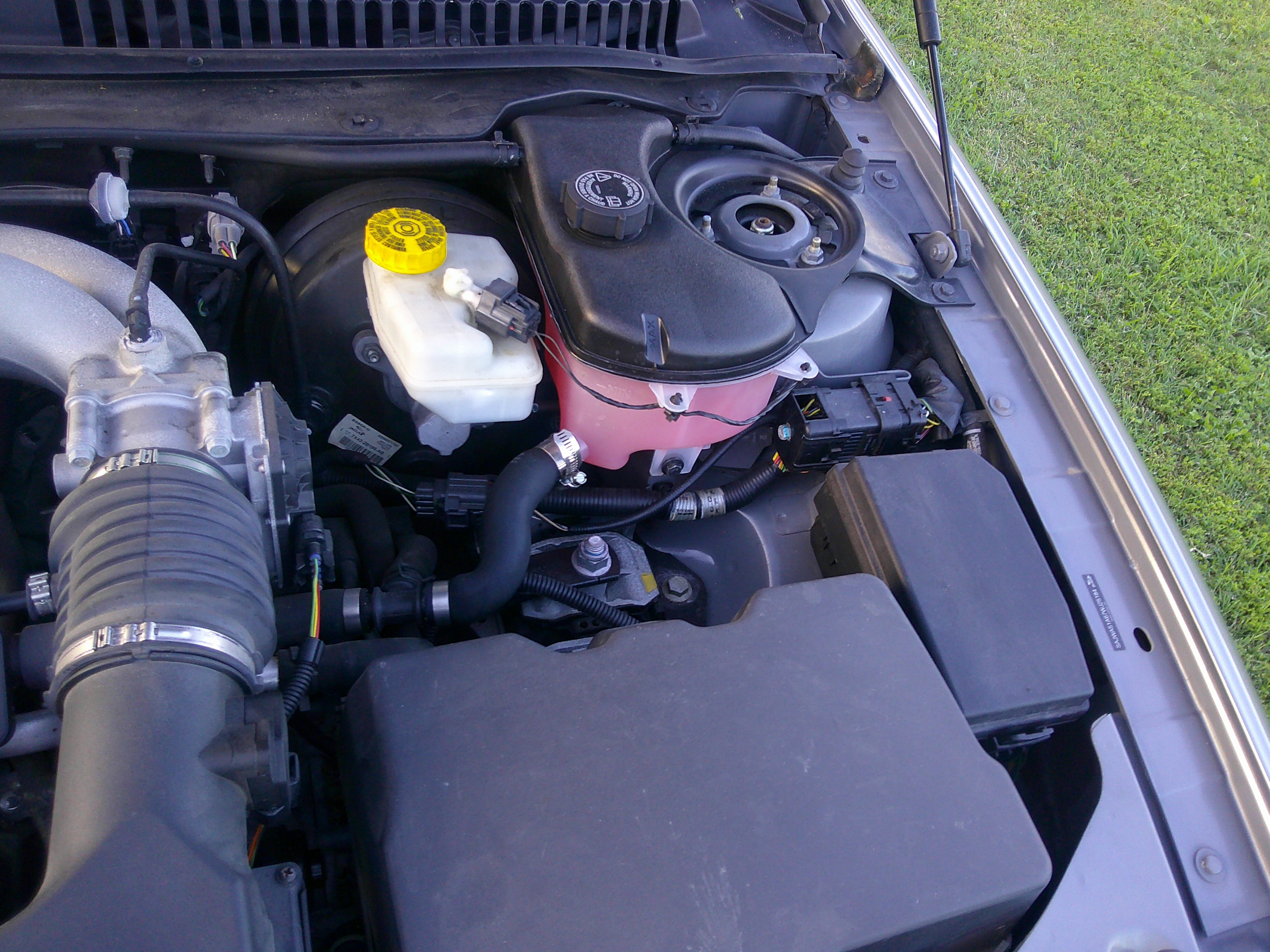 Engine bay detail showing coolant reservoir and brake fluid master cylinder.