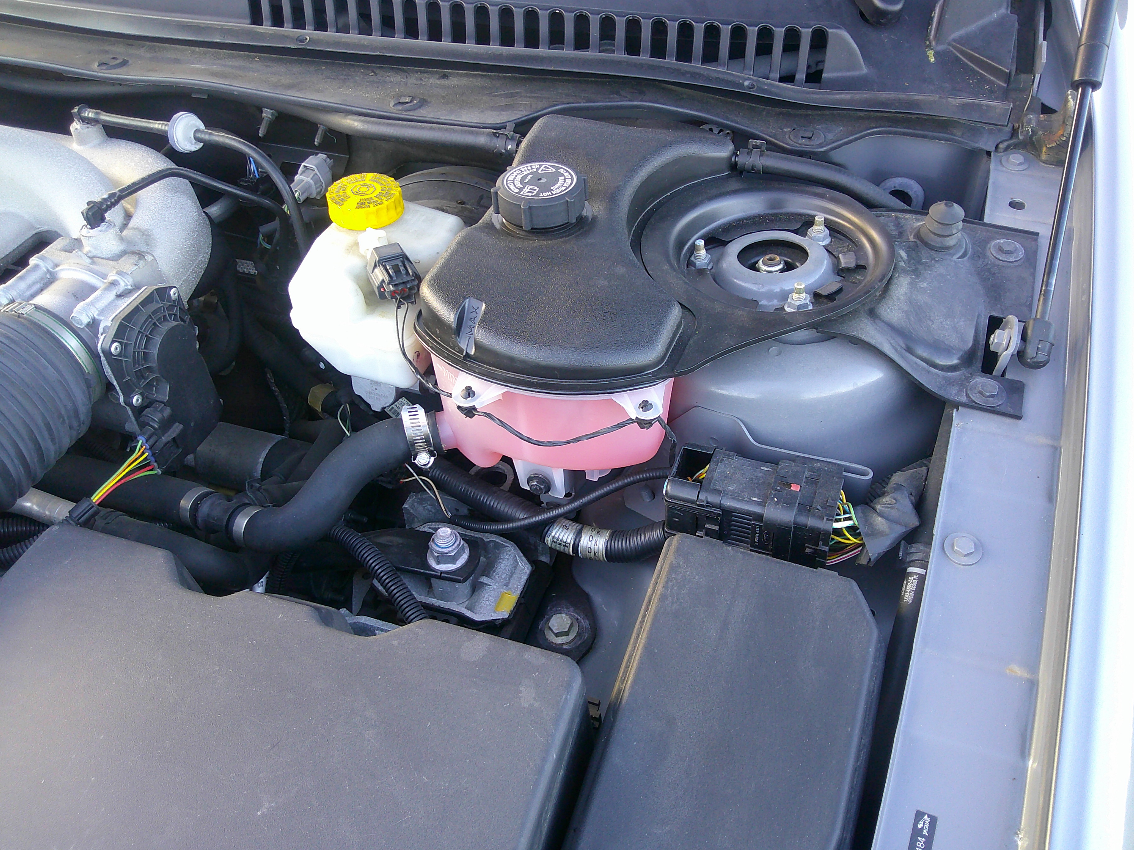 Engine bay view showing coolant reservoir and strut tower.