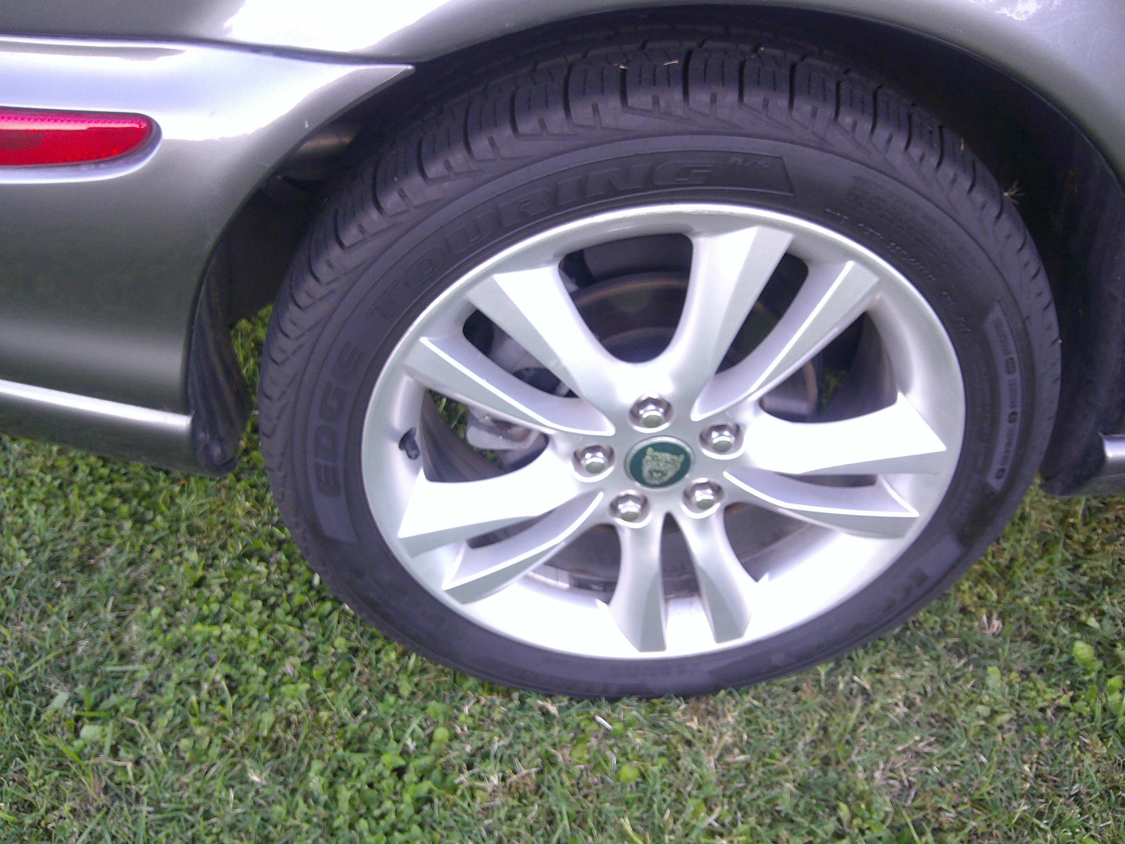 Close-up of alloy wheel and tire with Jaguar center cap.