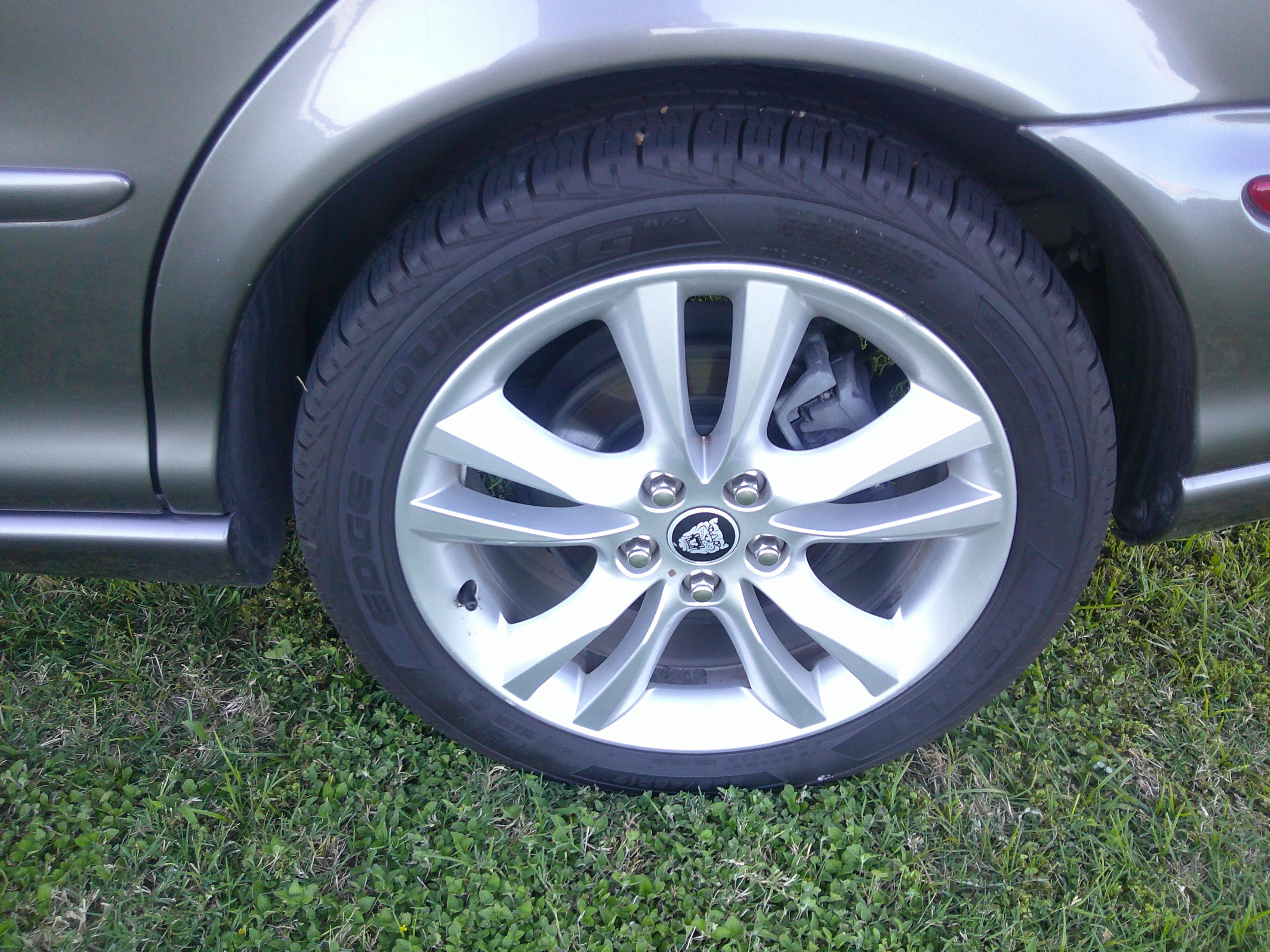 Close-up of alloy wheel and tire with Jaguar center cap.