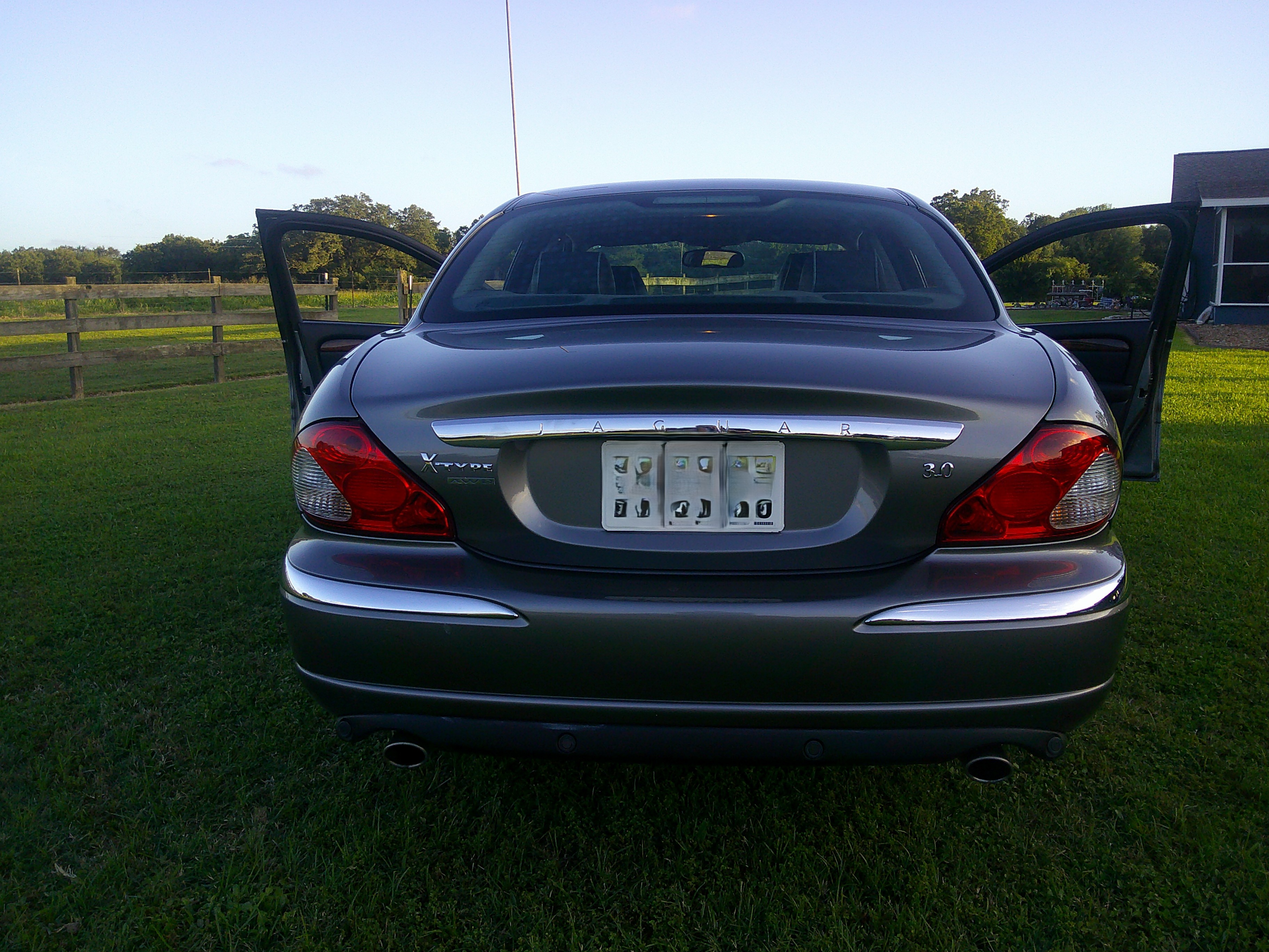 Rear view of a silver Jaguar X-Type with both front doors open