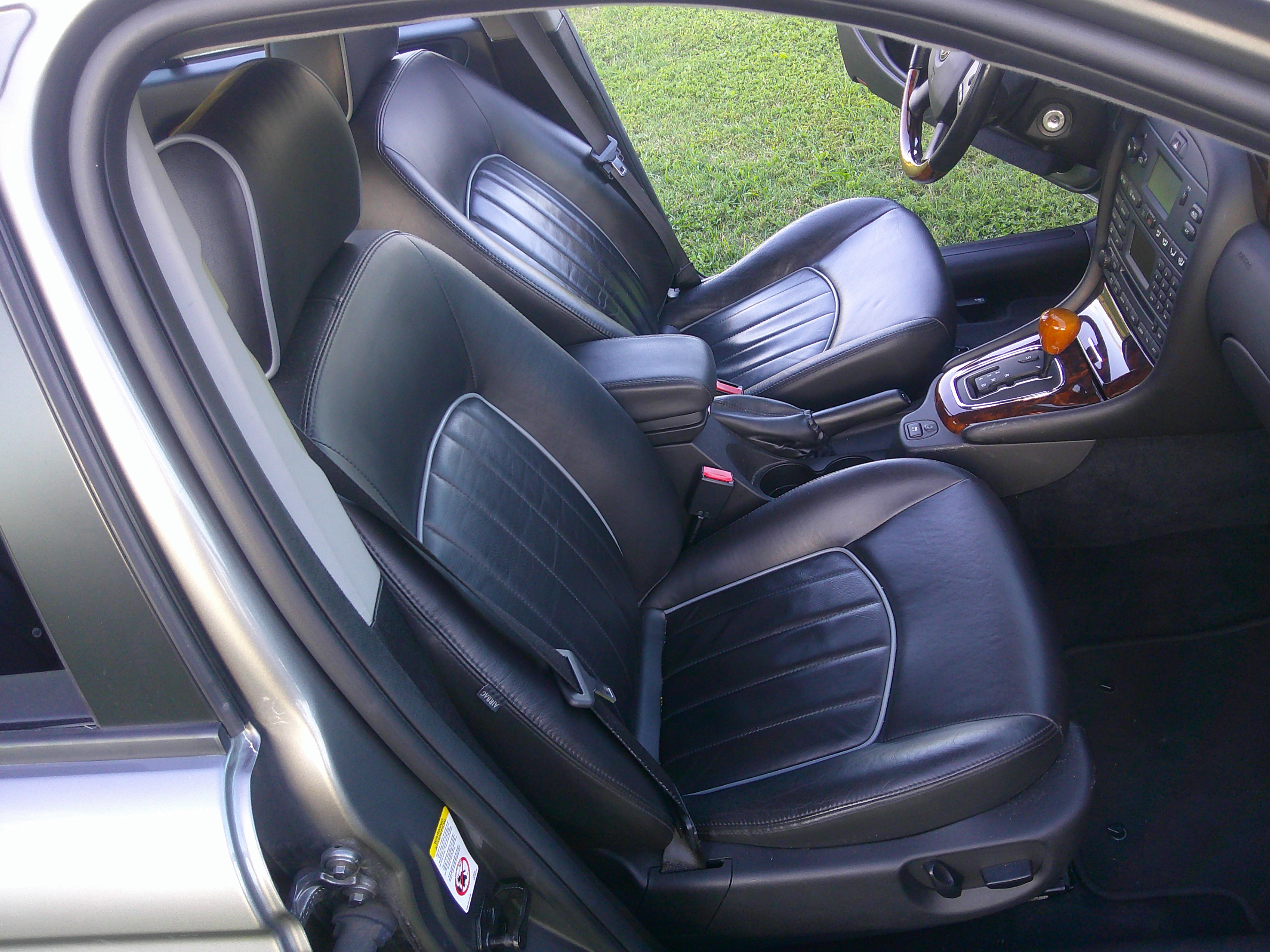 Front cabin view featuring black leather seats and center console.