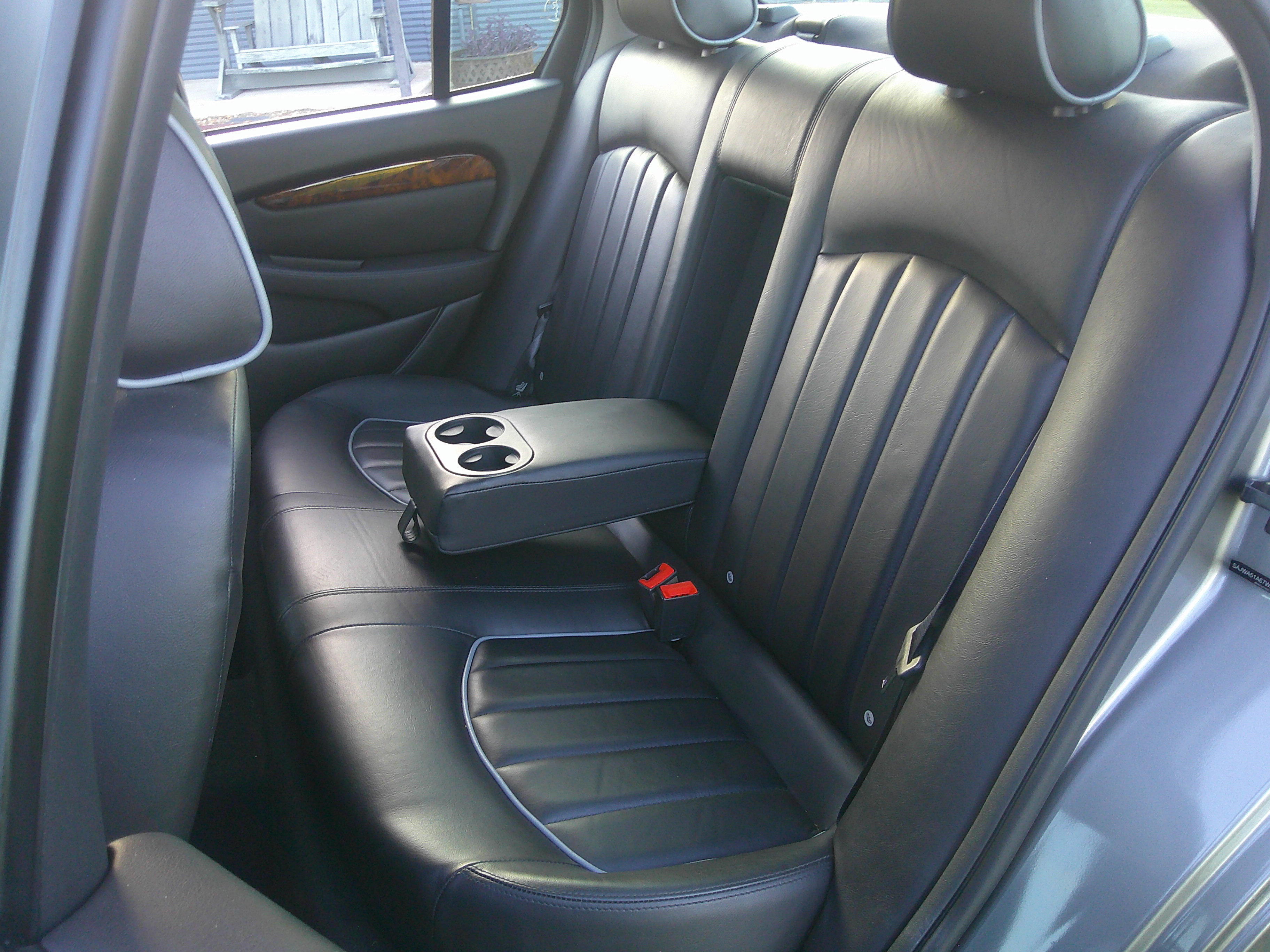 Rear leather bench seat with fold-down armrest and cupholders.
