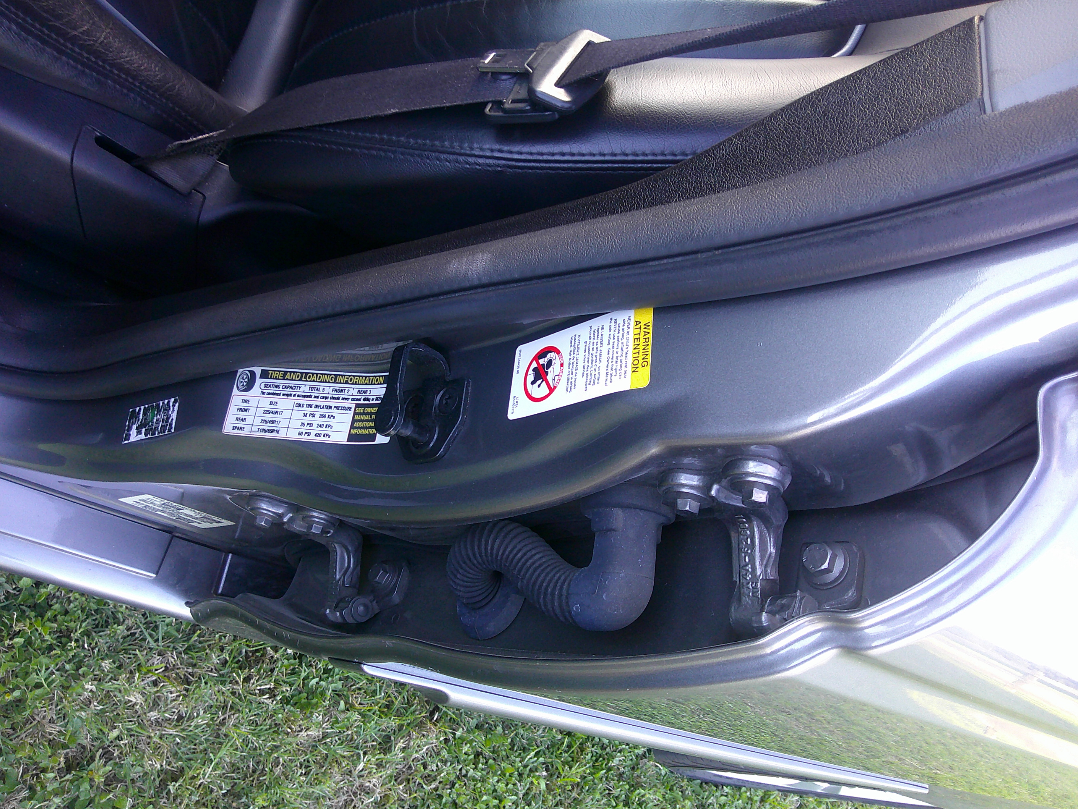 Vehicle door jamb with tire pressure and safety information stickers.