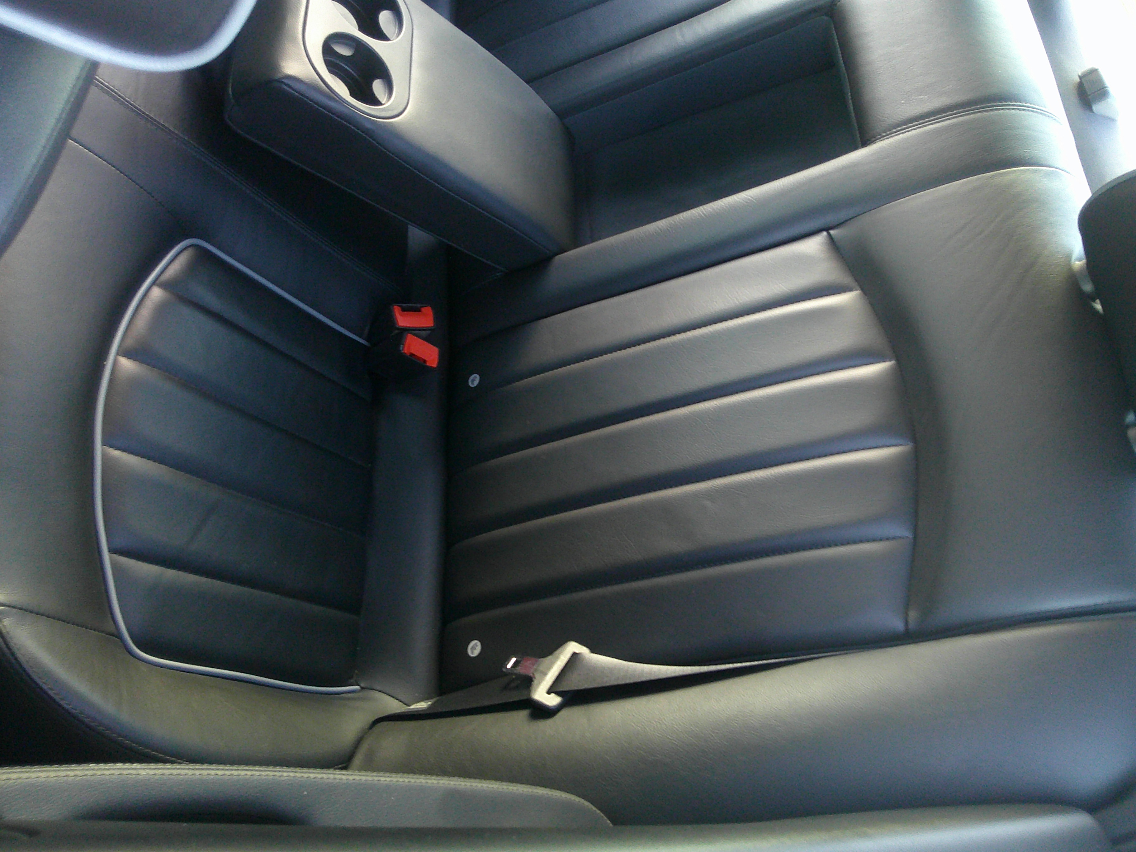 Rear black leather seats with center armrest and cup holders