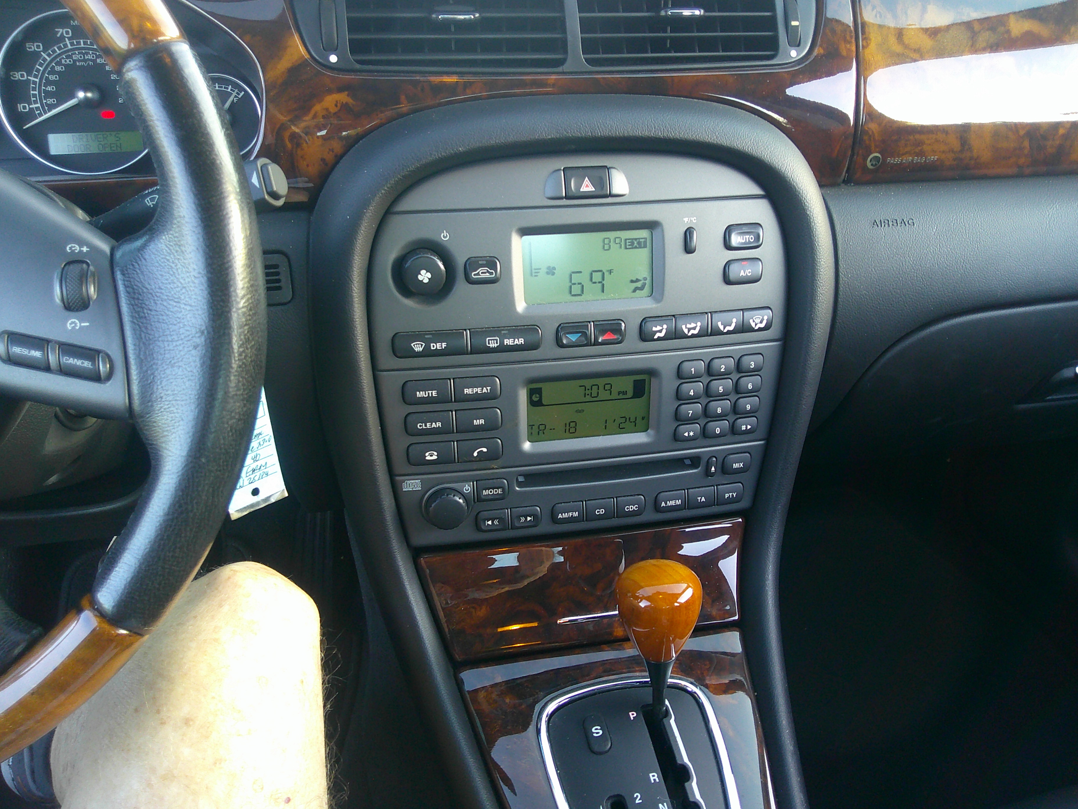 Center console assembly with climate controls, radio unit, and wood grain trim.