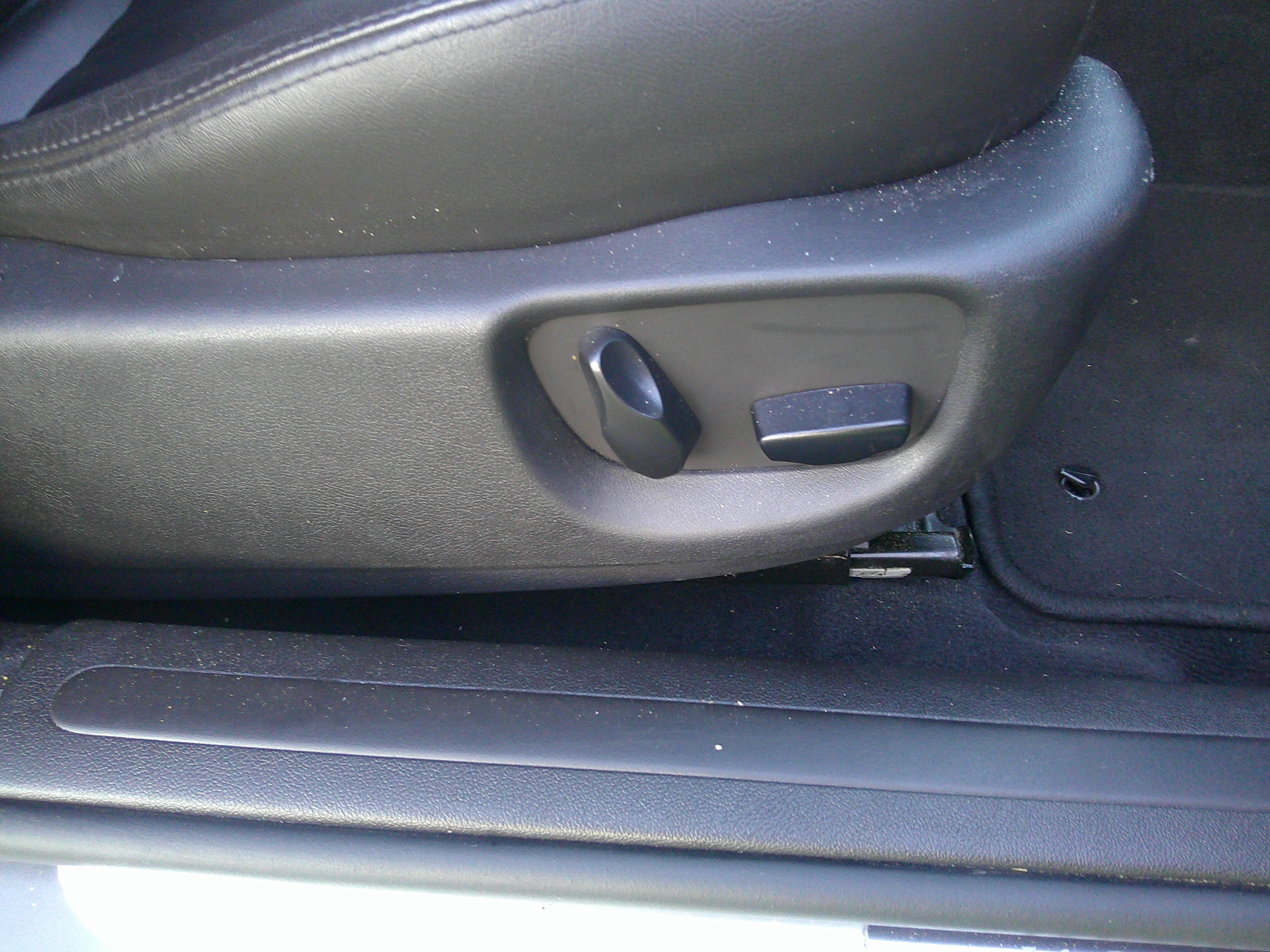 Detail of power seat adjustment controls and door sill.