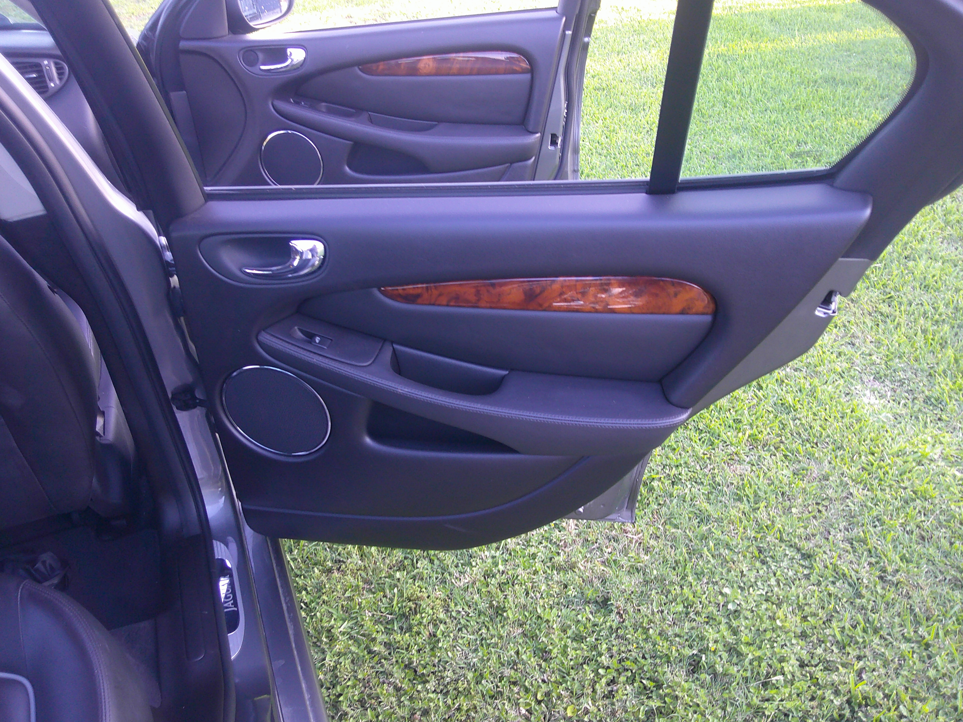 Rear passenger door panel with wood grain trim and speaker