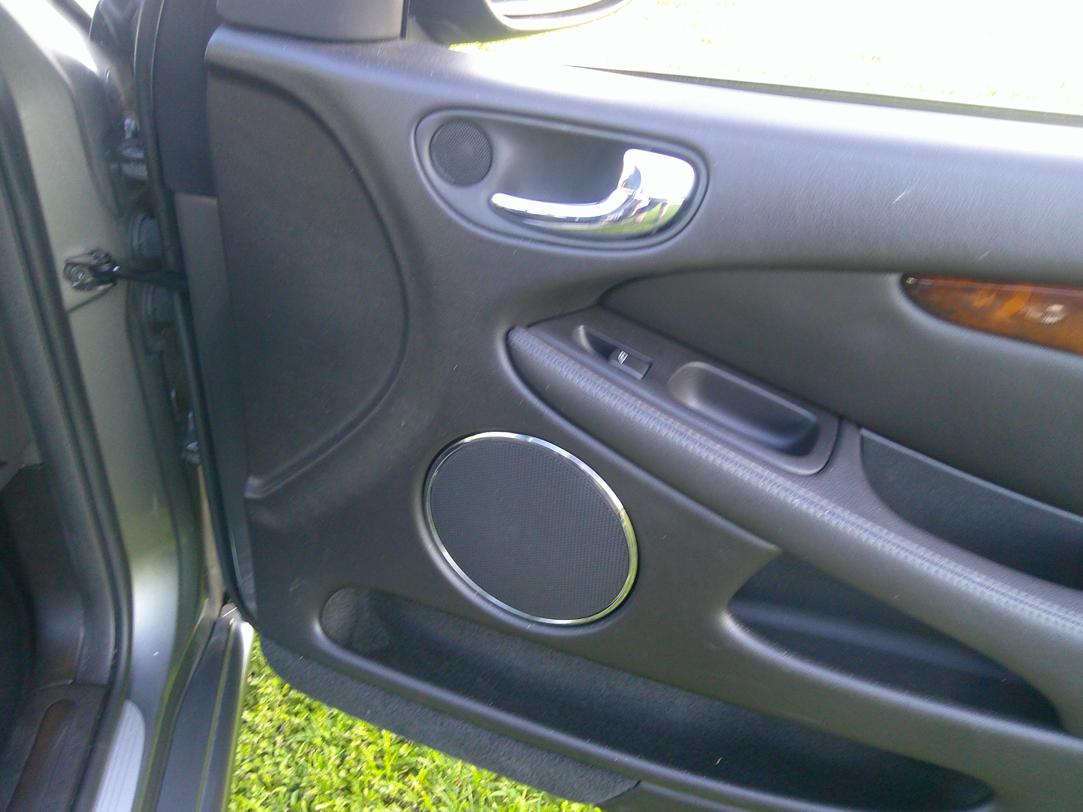 Passenger side door panel with chrome handle and speaker grille
