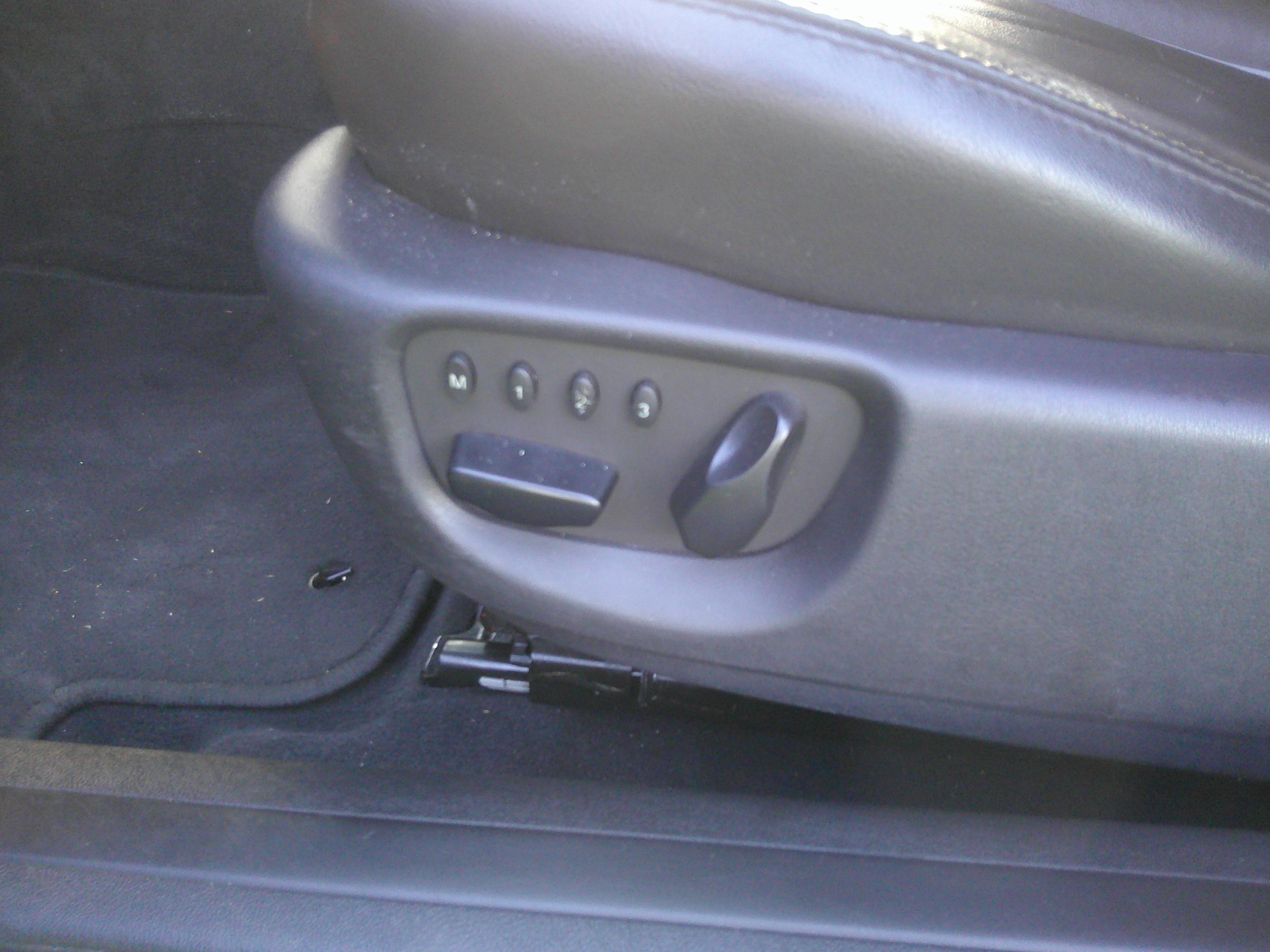Power seat adjustment buttons and memory settings on driver's seat base.