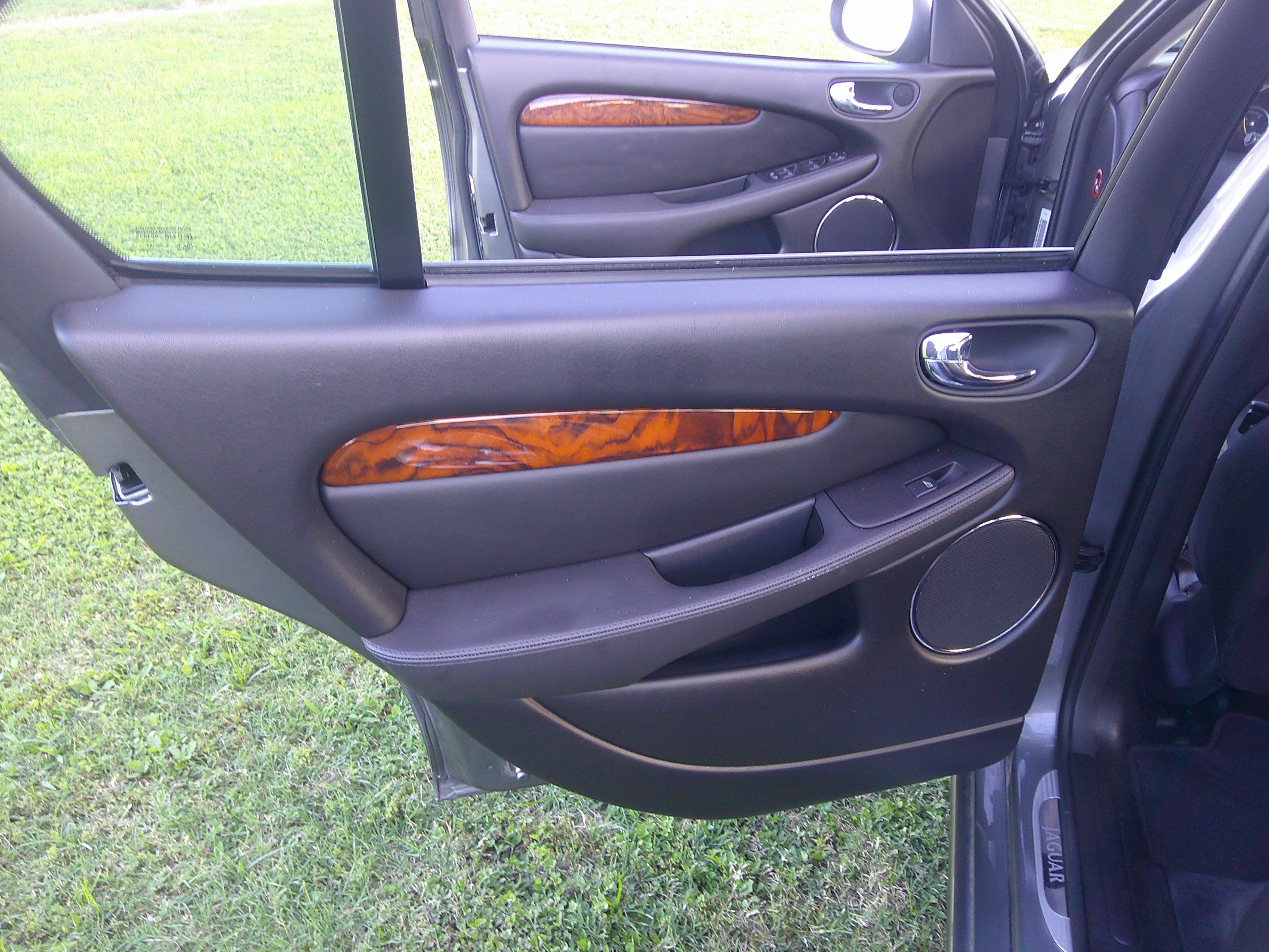 Rear interior door panel with wood grain trim and speaker
