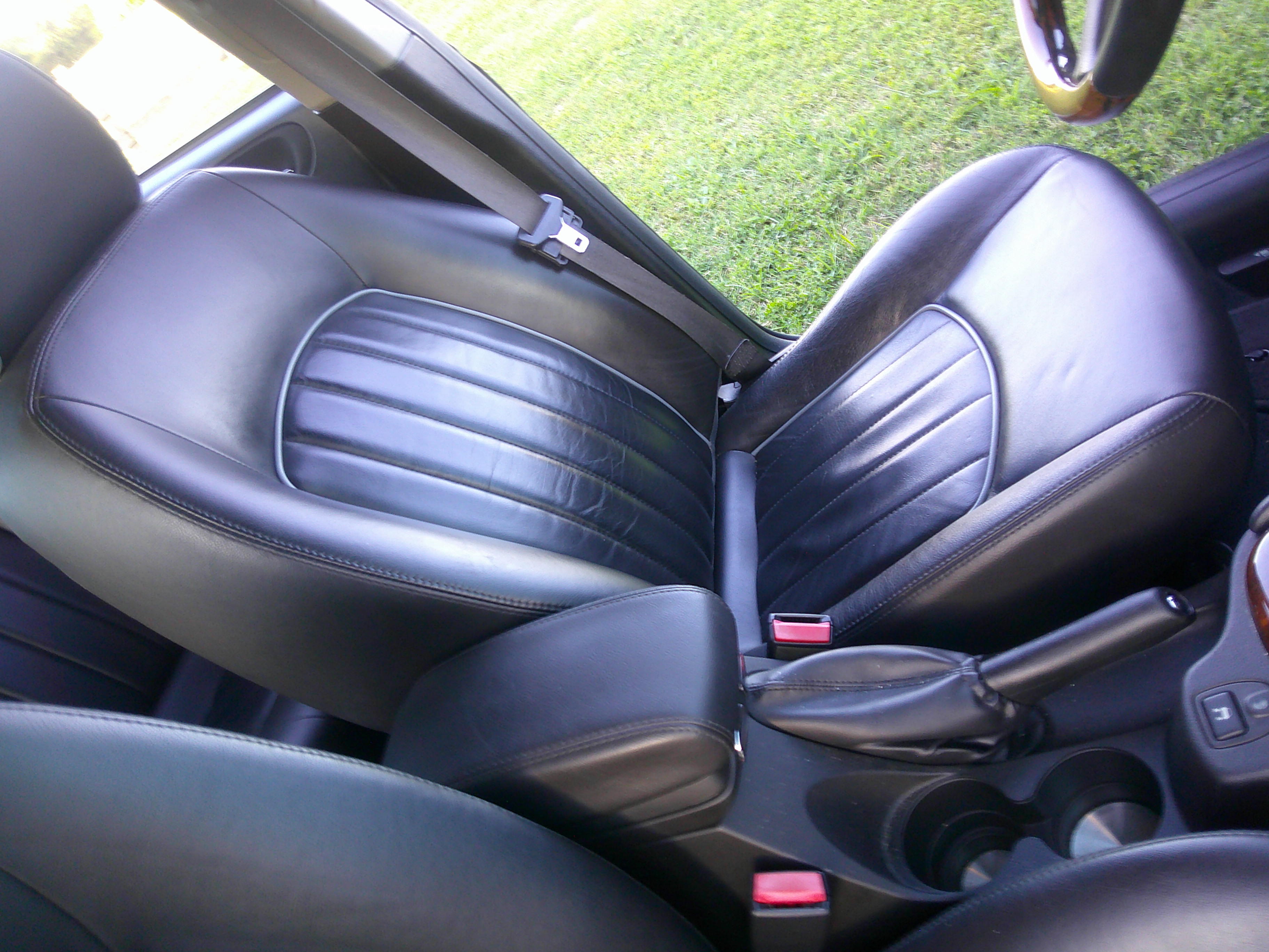 Black leather front seats, armrest, and parking brake lever.