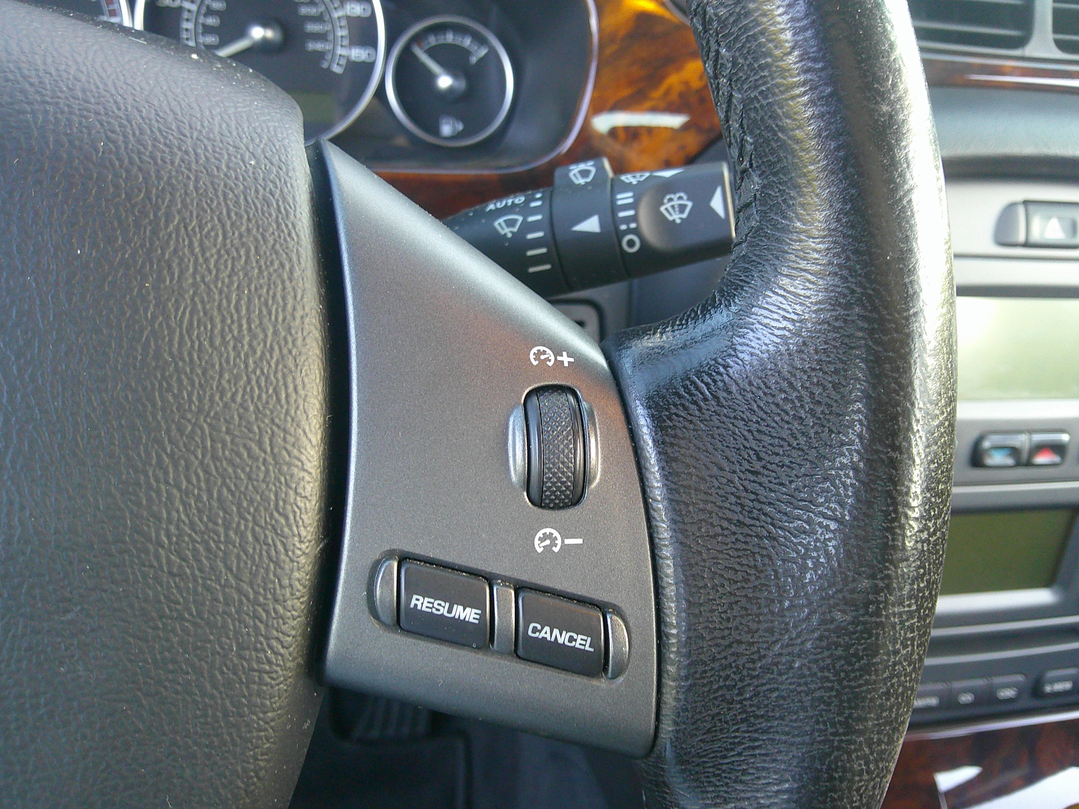 Detail of steering wheel cruise control buttons and wiper stalk.