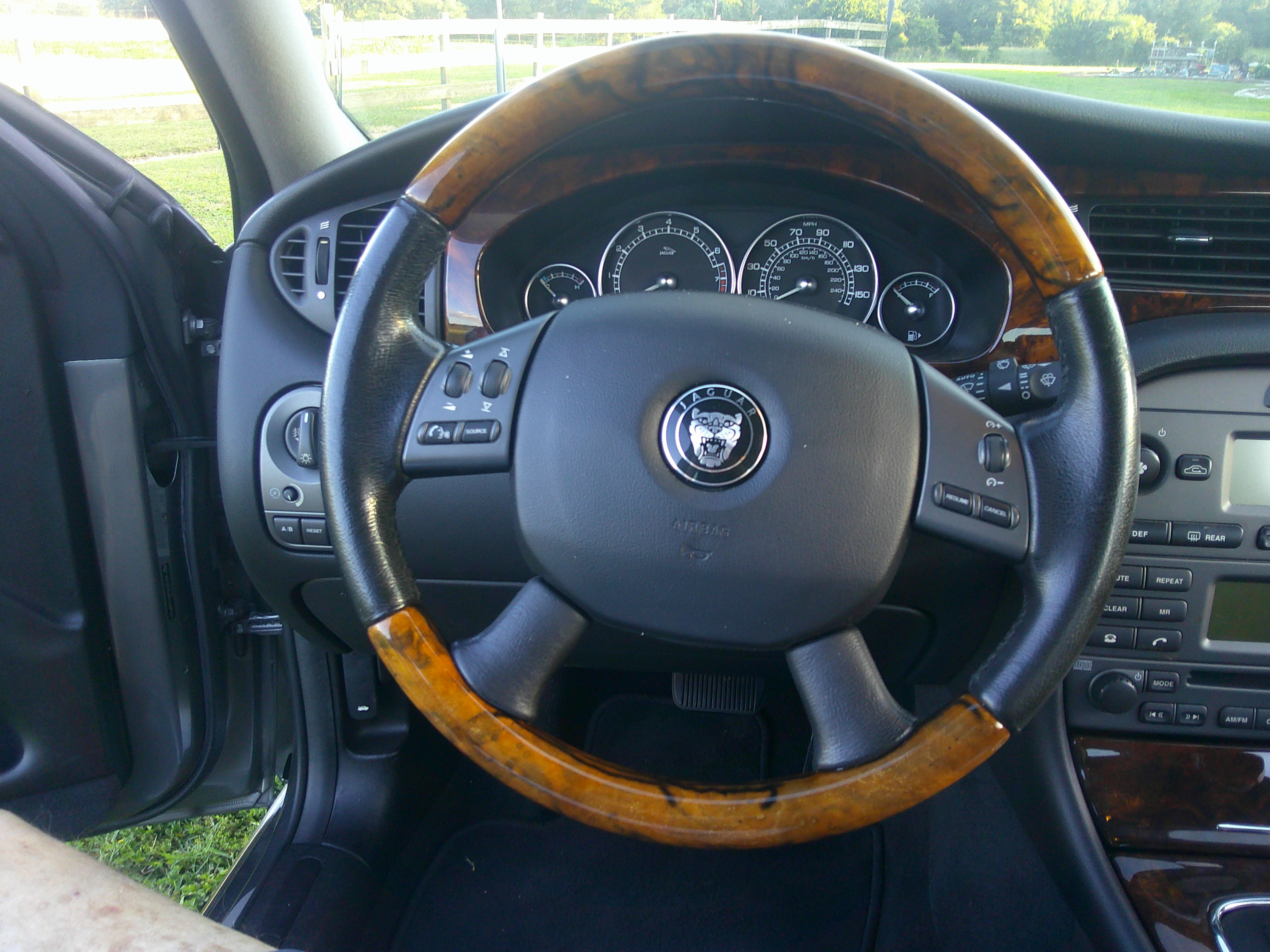 View of the wood-trimmed steering wheel and instrument cluster.