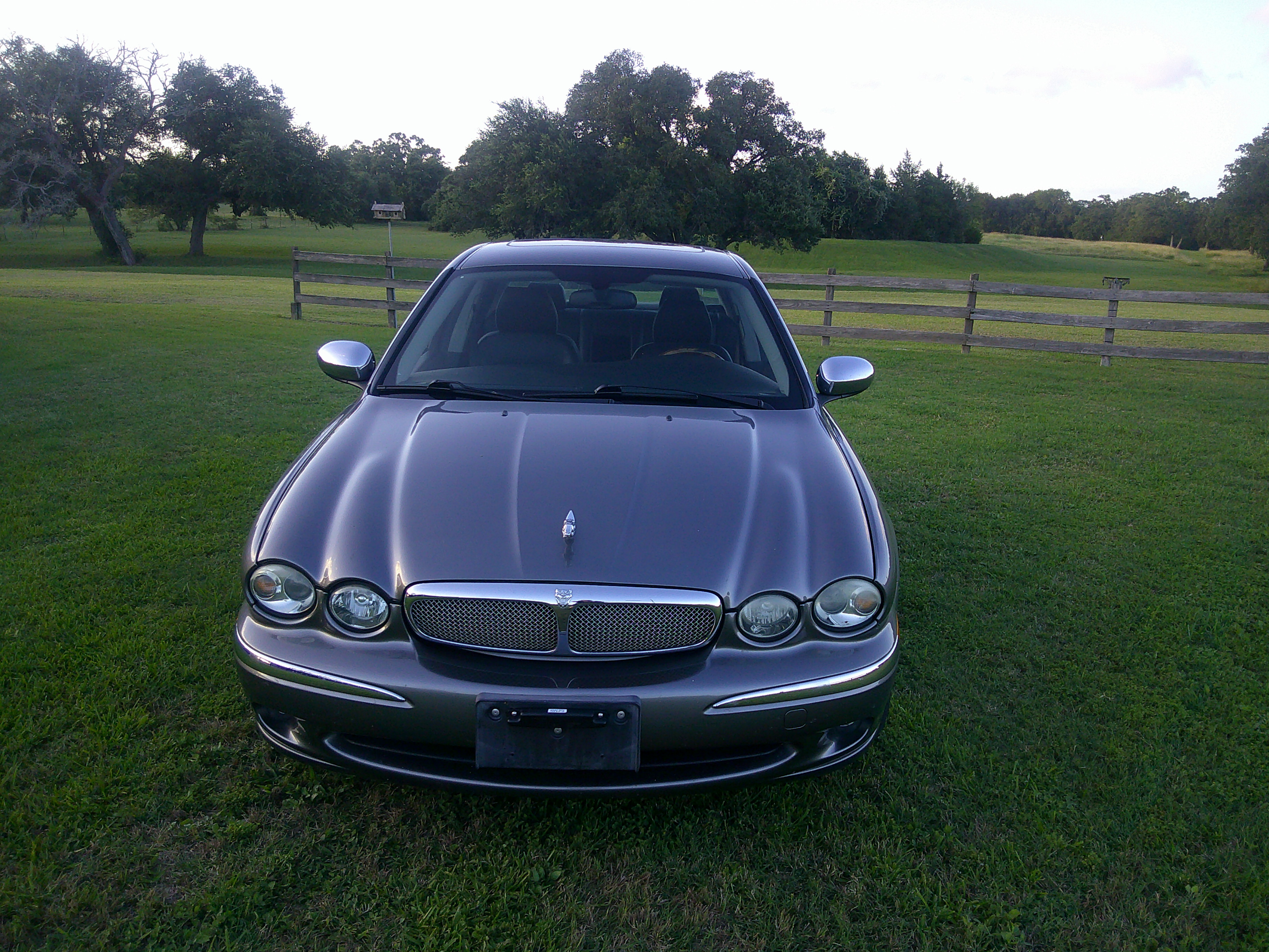 Front view of a gray Jaguar sedan featuring signature grille and hood ornament