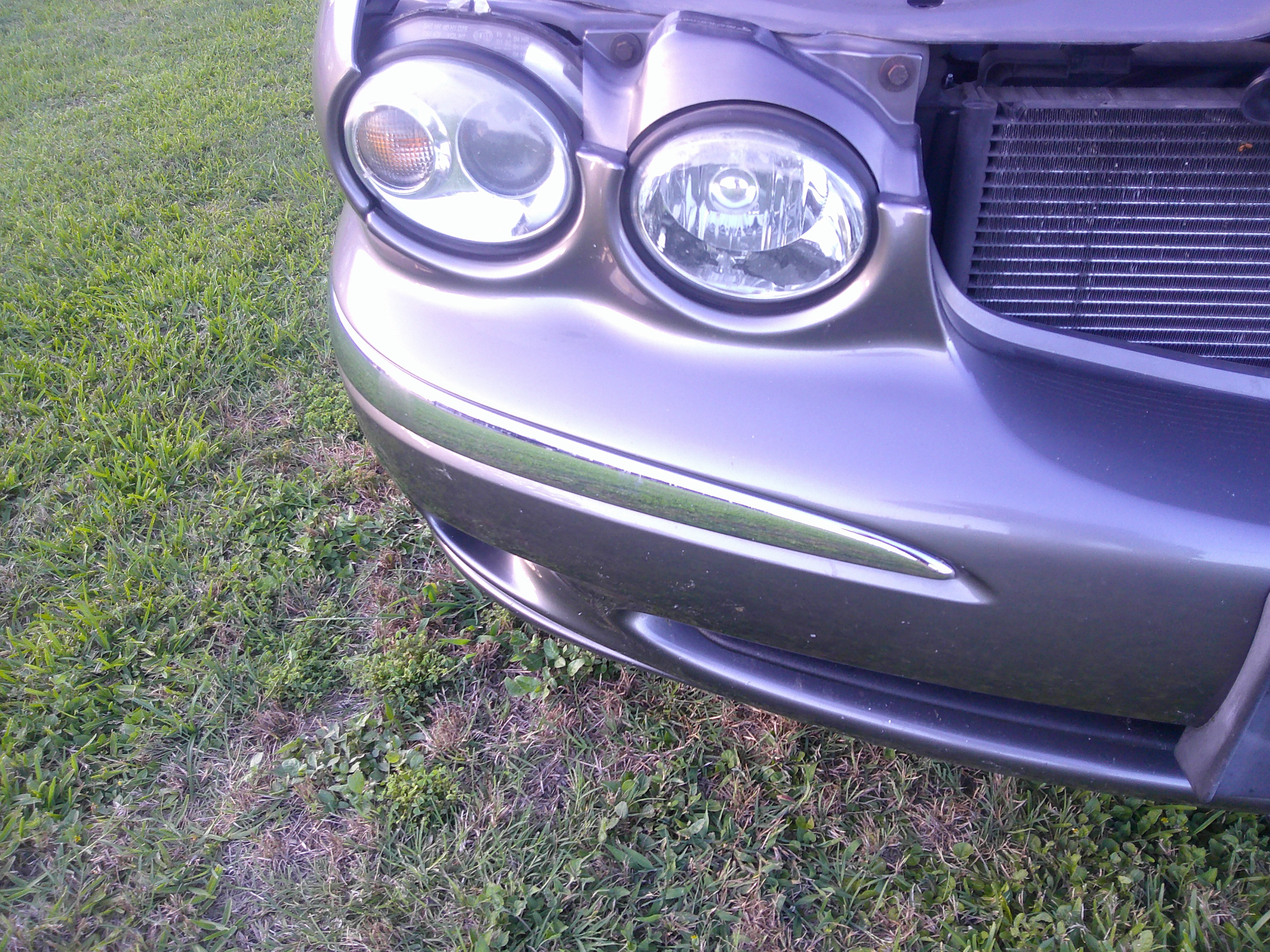 Close-up of the front driver-side headlight assembly and bumper trim