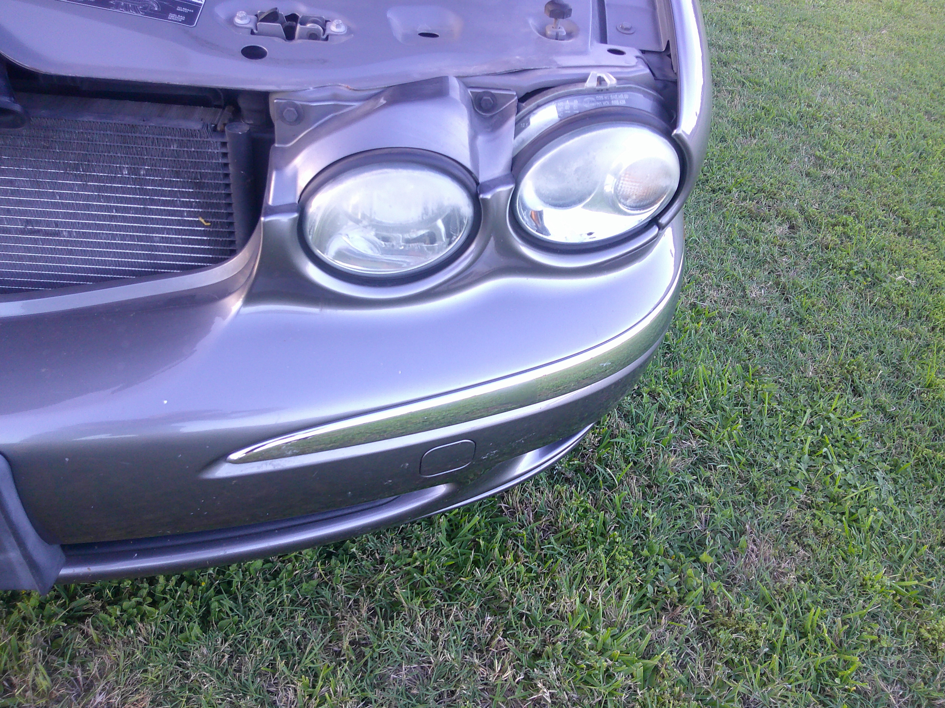 Close-up of the front passenger headlight and bumper trim