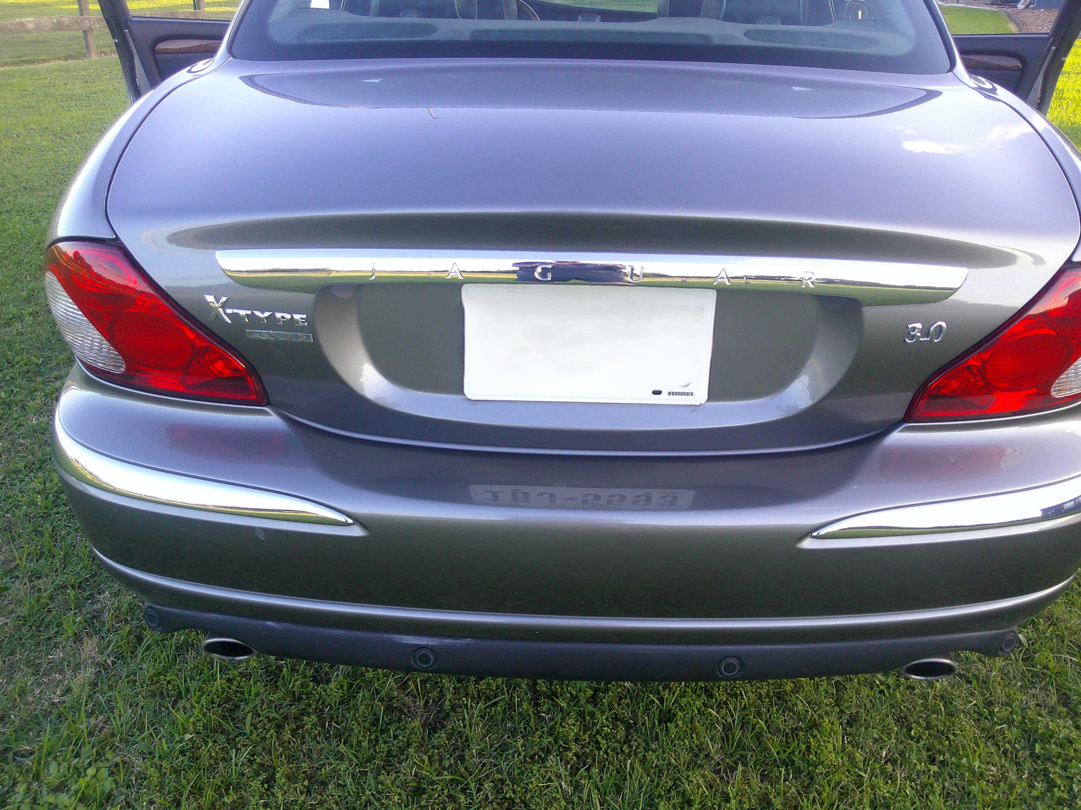 Rear view of grey Jaguar X-Type showing trunk, taillights, and badging.