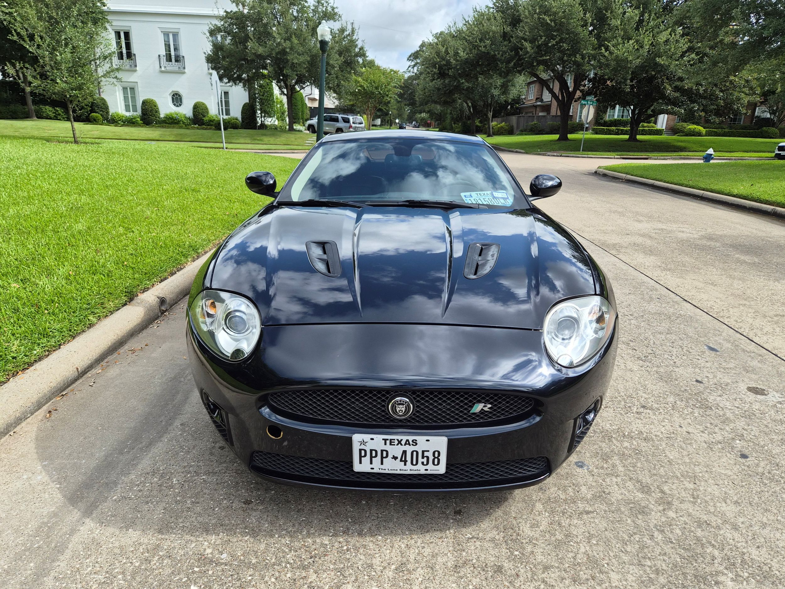 Front view of black Jaguar XKR parked on residential street