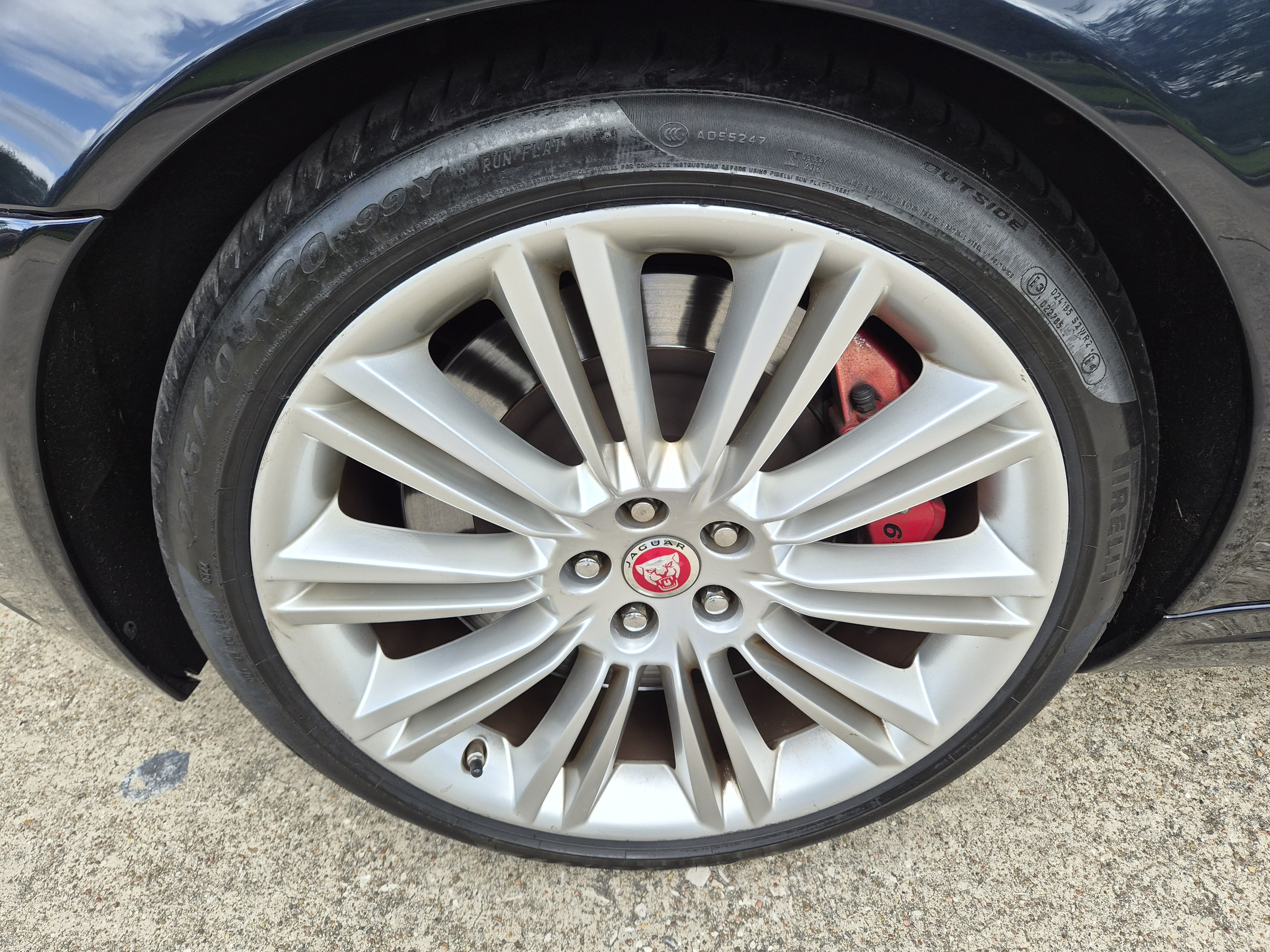 Close-up of Jaguar alloy wheel with Pirelli tire and red brake caliper.