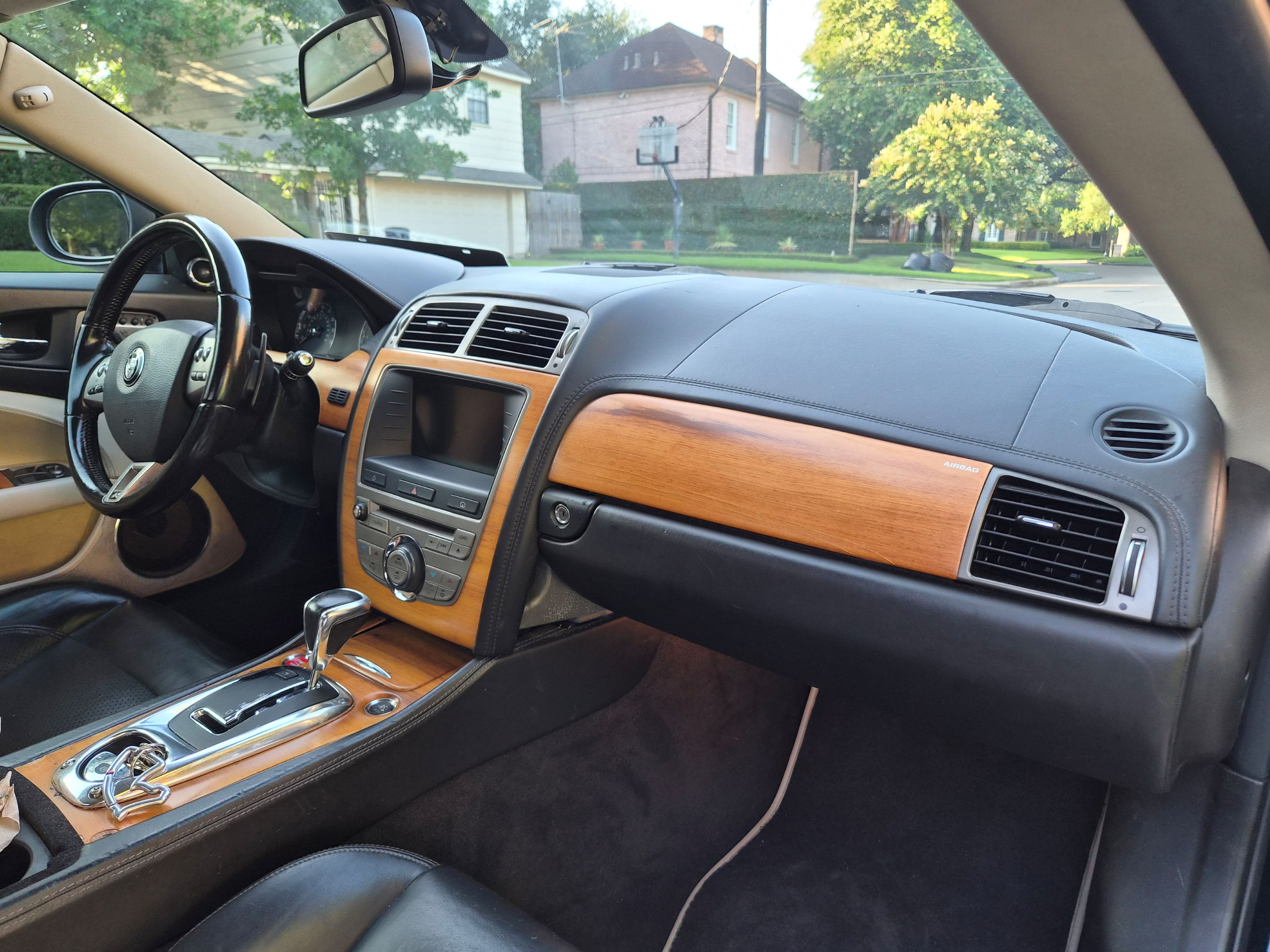 View of the dashboard, center console, and steering wheel with wood trim.
