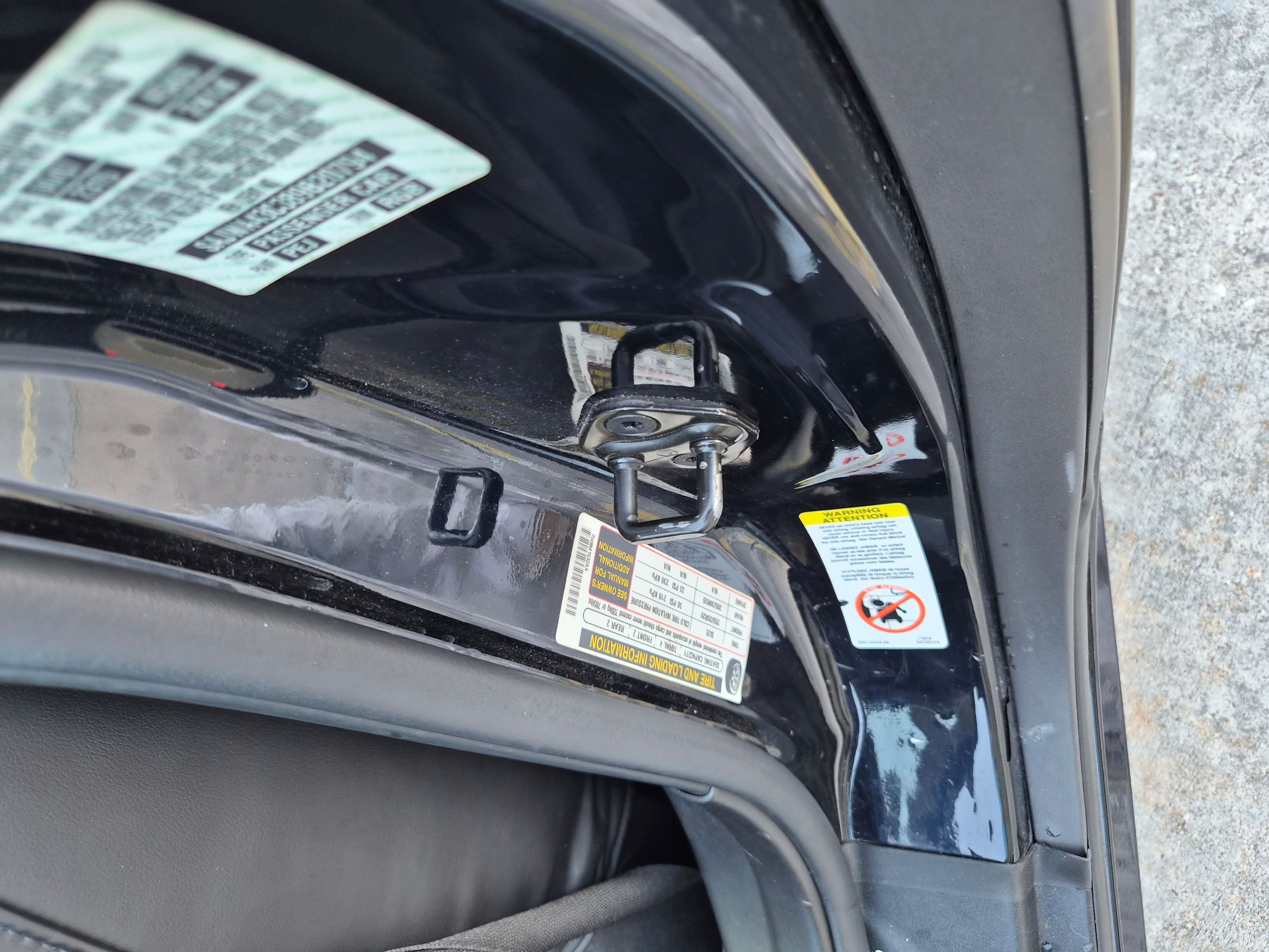 Vehicle identification number and tire pressure stickers on door jamb