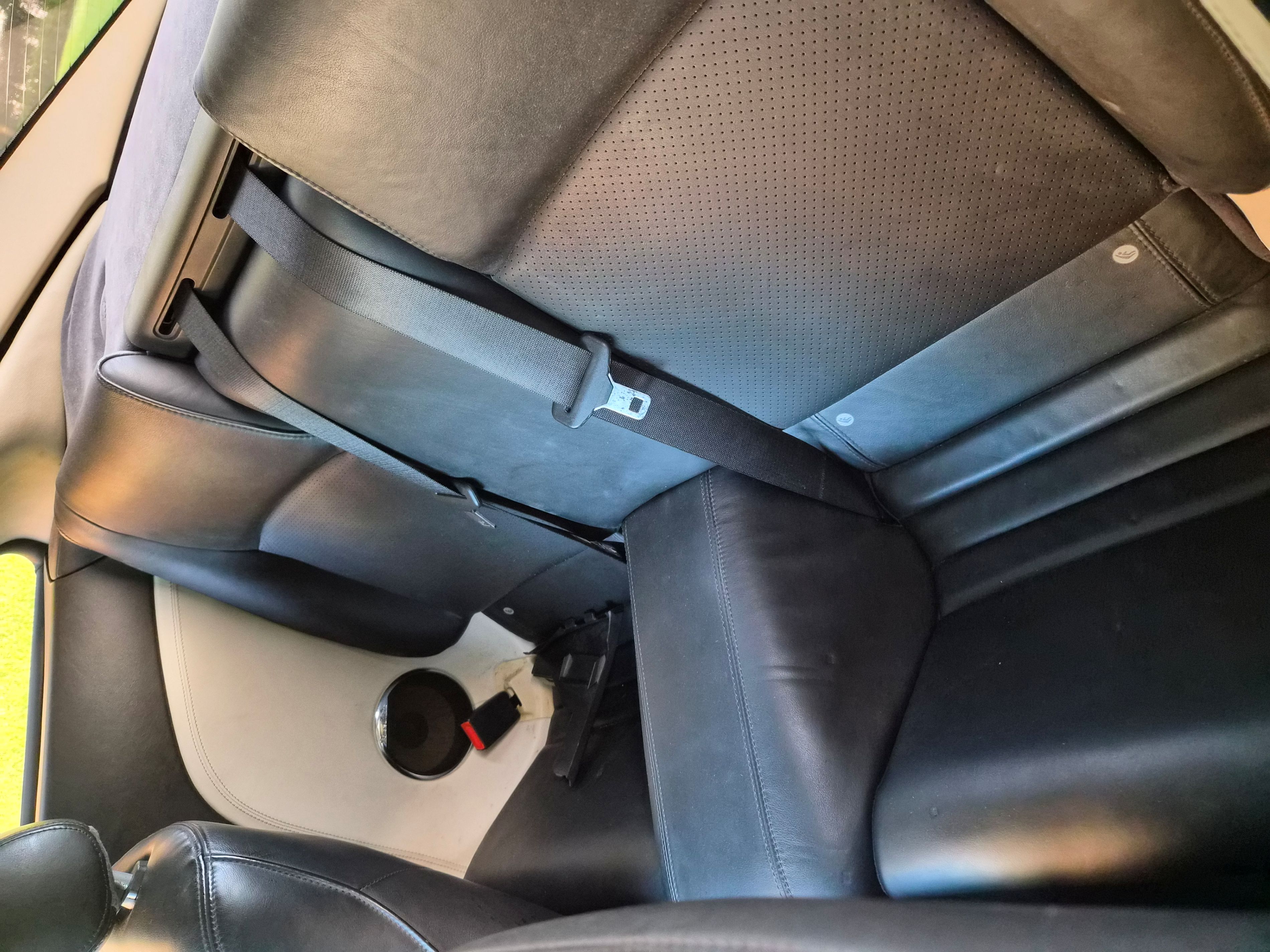 Rear passenger cabin featuring black leather seats and center console.