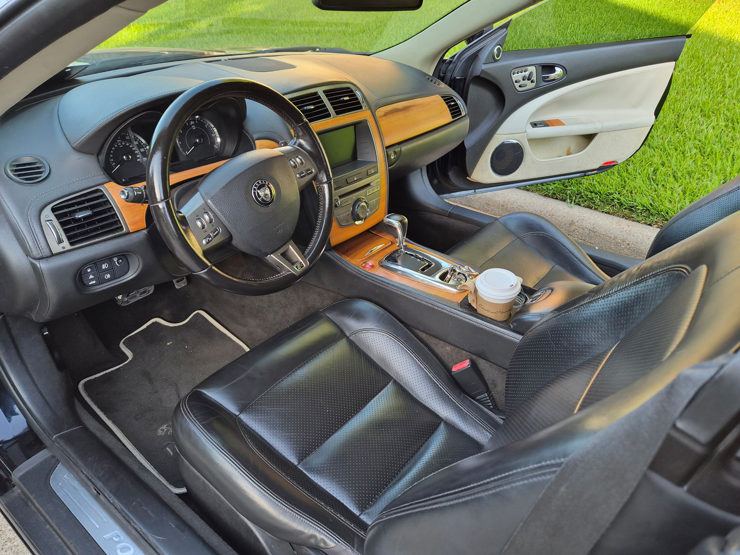 Driver's side interior with black leather seats and wood trim