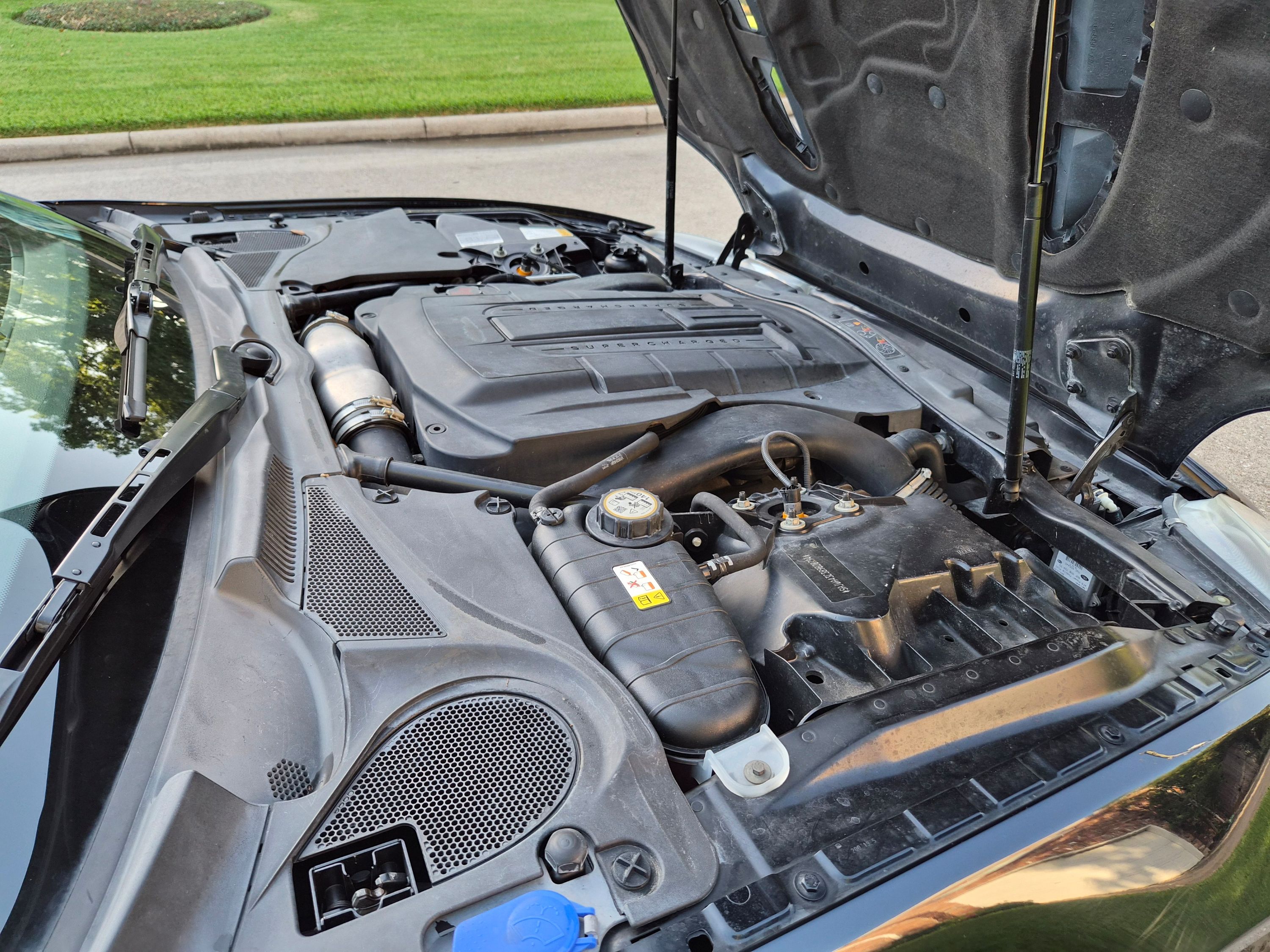 View of the engine bay featuring the supercharger cover and coolant reservoir.