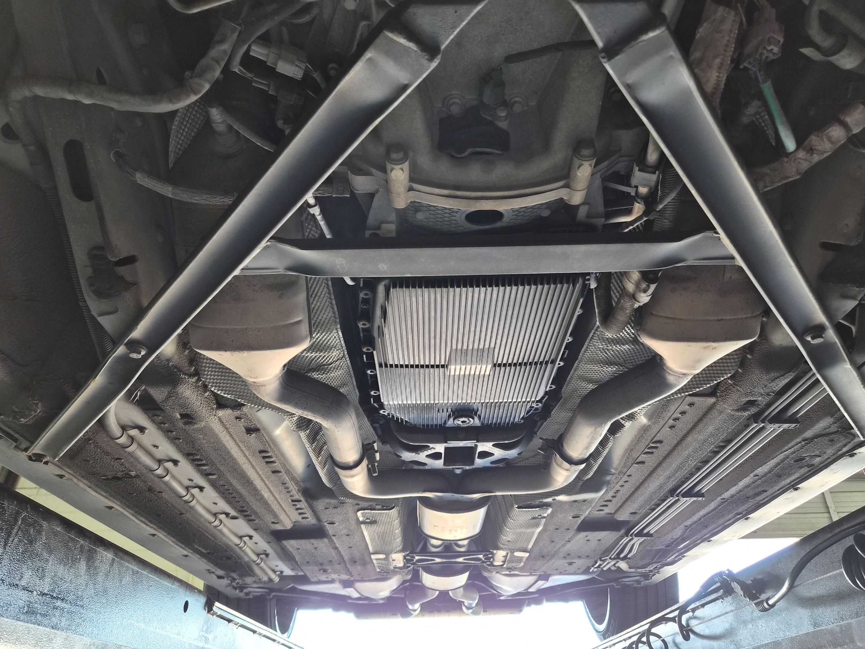 Underbody view showing transmission pan, exhaust pipes, and chassis cross bracing.