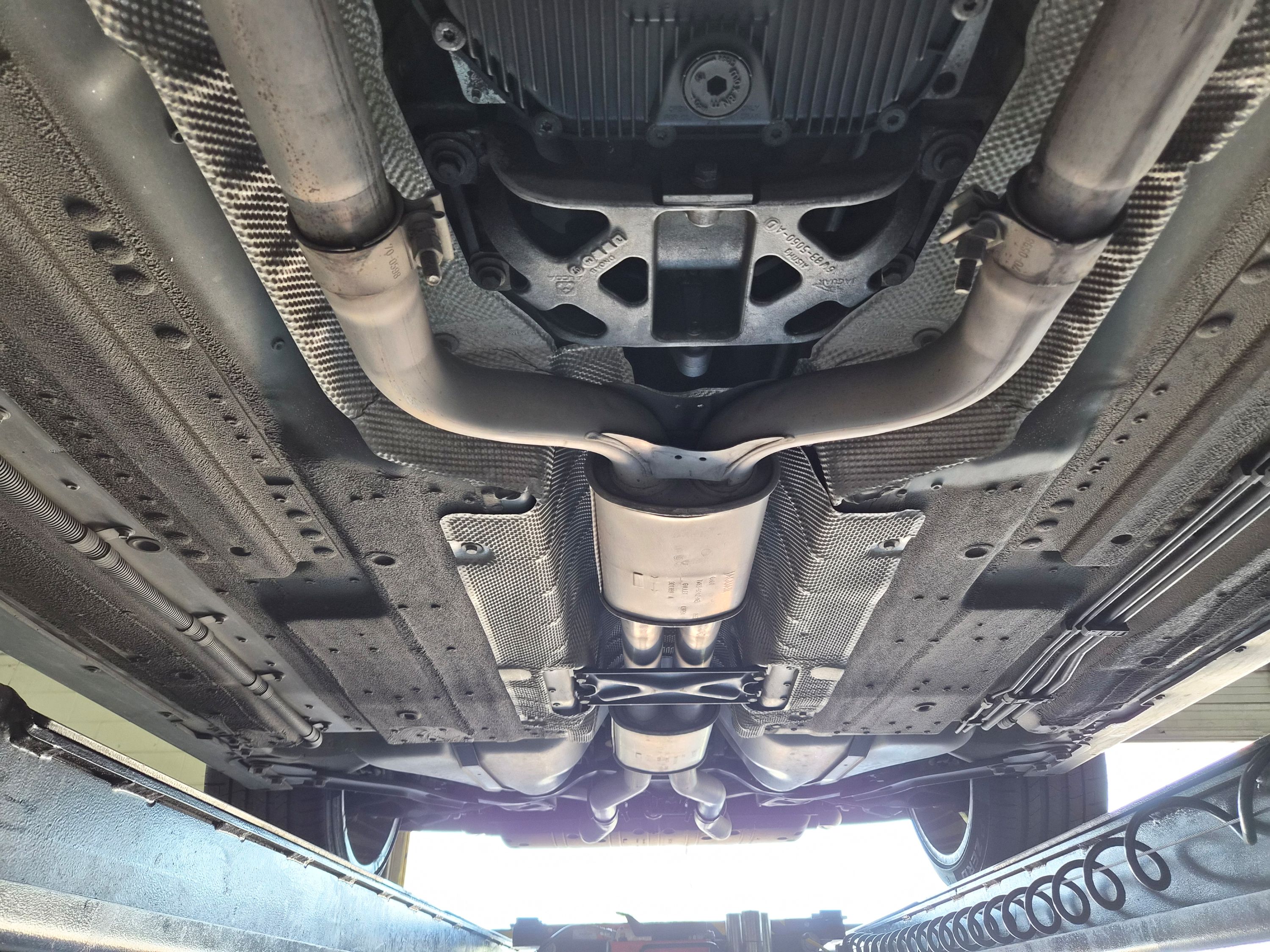 Chassis view showing exhaust system, heat shielding, and undercoating.