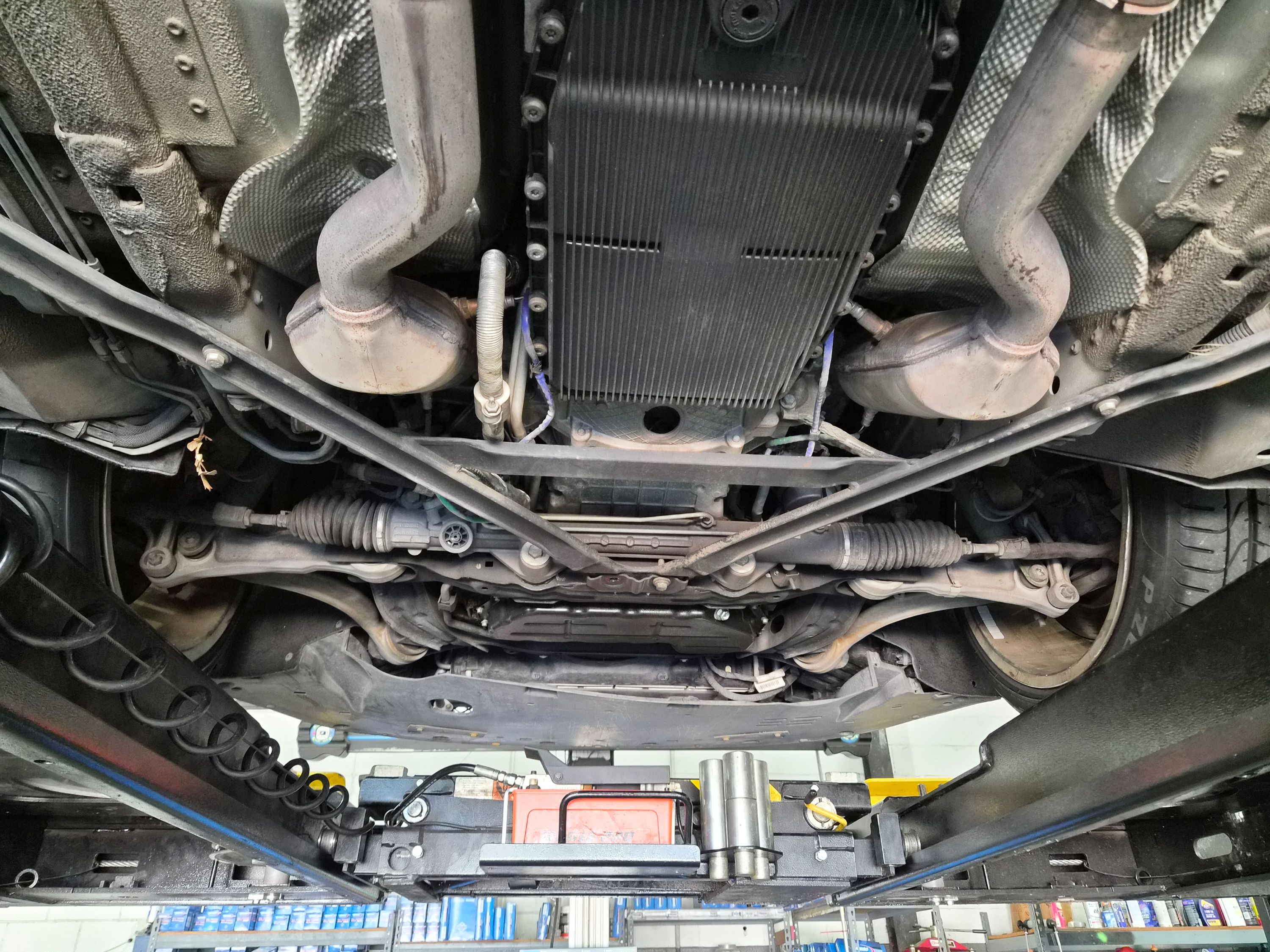 Undercarriage view showing oil pan, exhaust, and suspension components.