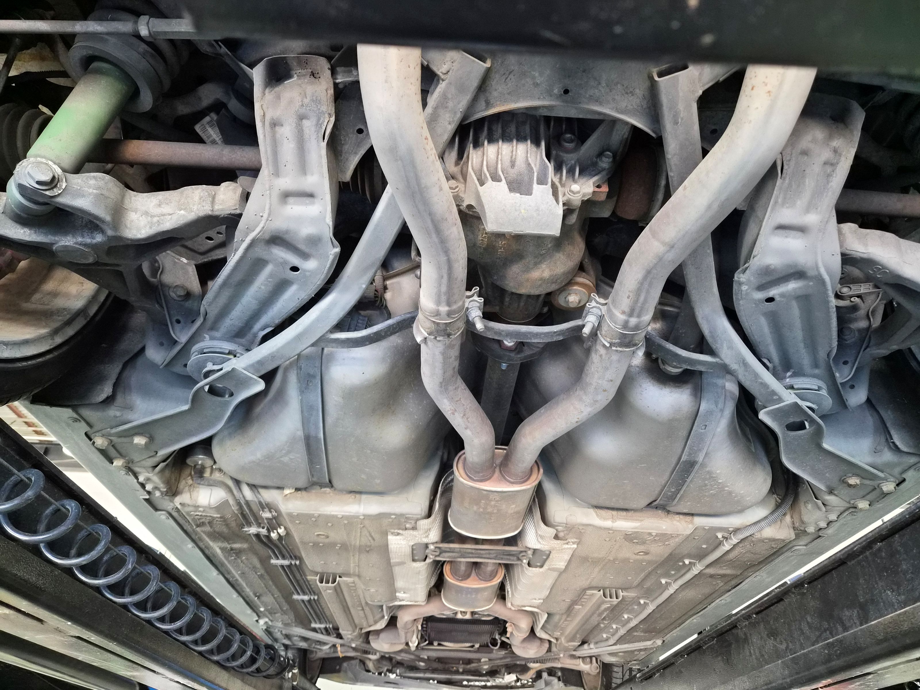 Underbody view showing dual exhaust system, differential, and suspension components.