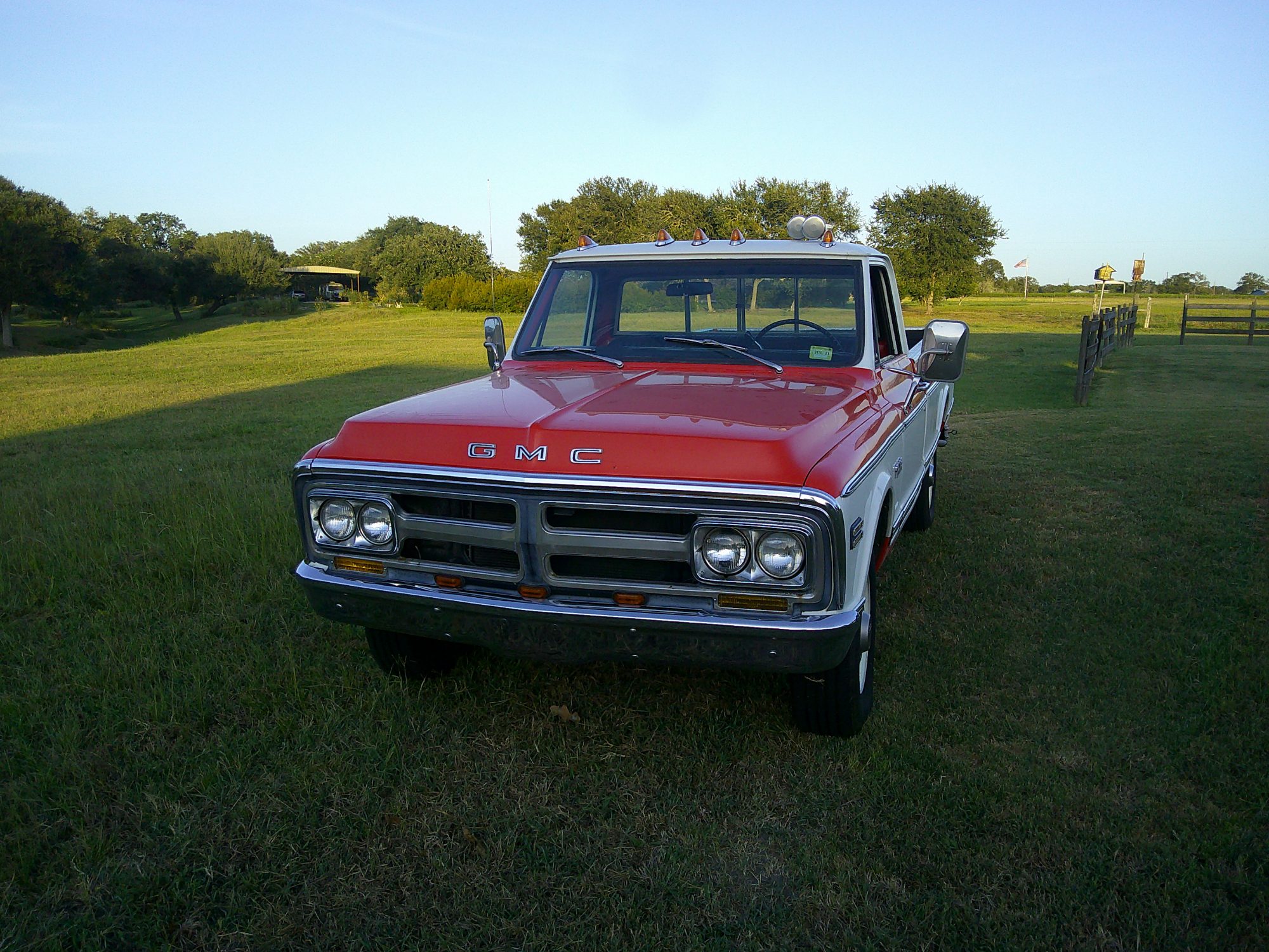 Front three-quarter view of a two-tone red and white GMC pickup truck.