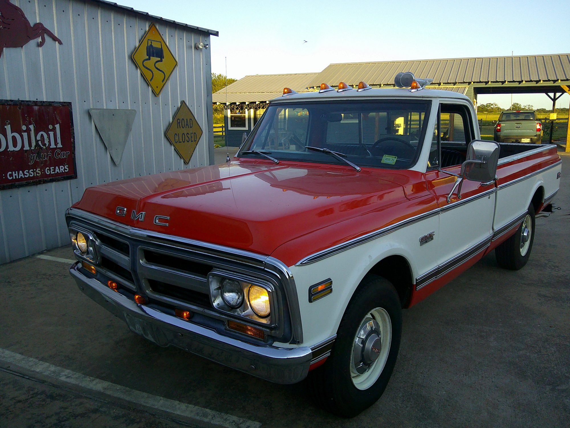 Front three-quarter view of a two-tone red and white GMC pickup truck.