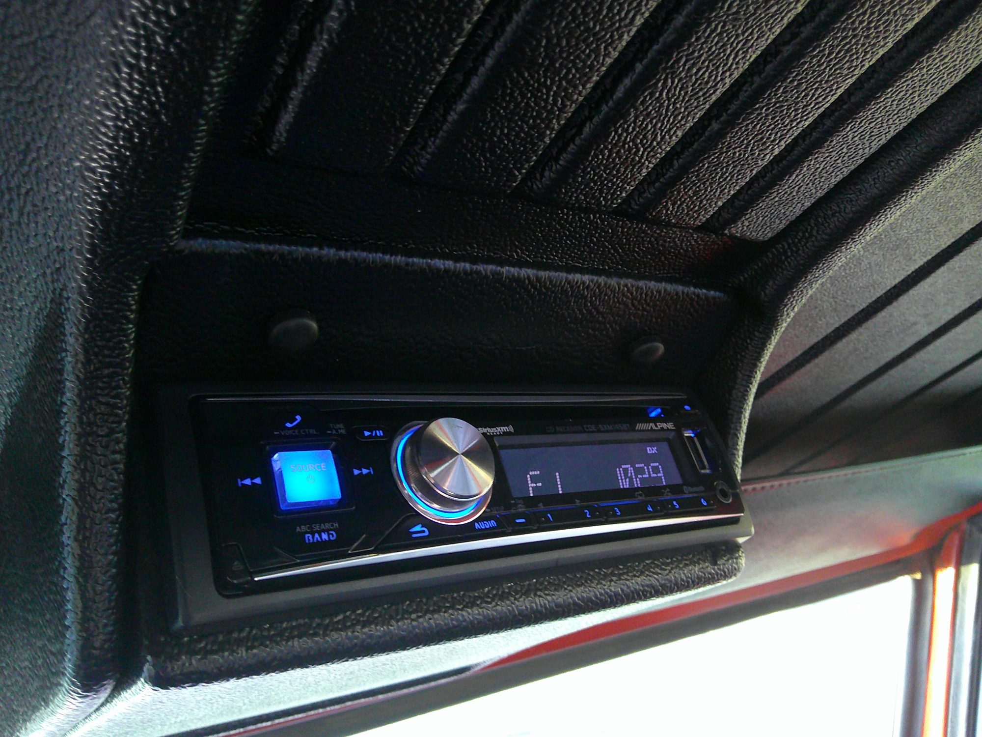 Aftermarket Alpine head unit mounted in an overhead console.