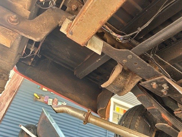 Rear underbody showing frame rails, leaf springs, and exhaust pipe.