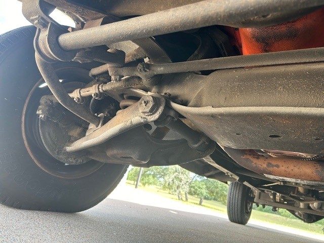 Lower front suspension and chassis components with visible tire