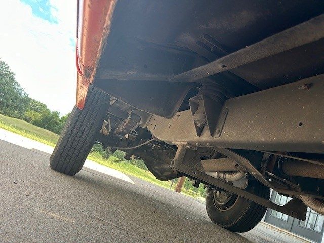 Undercarriage view showing frame rails, leaf springs, and rear axle.