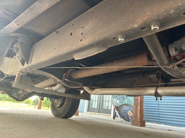 Undercarriage view showing frame rail, driveshaft, and exhaust system.