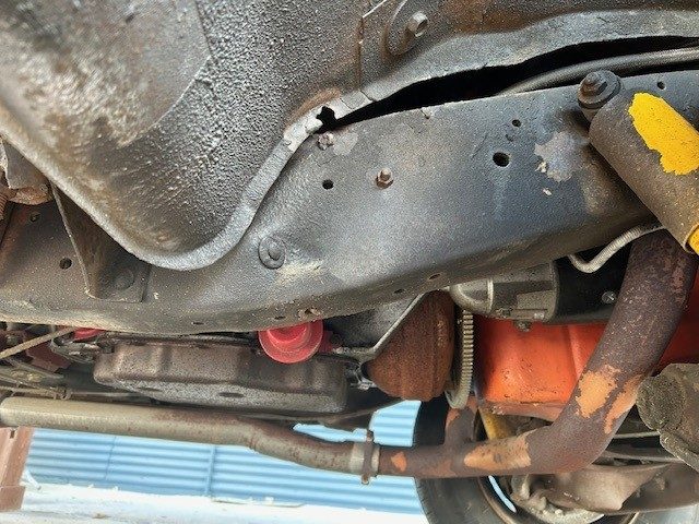 Underbody view showing frame rail, exhaust pipe, and transmission pan